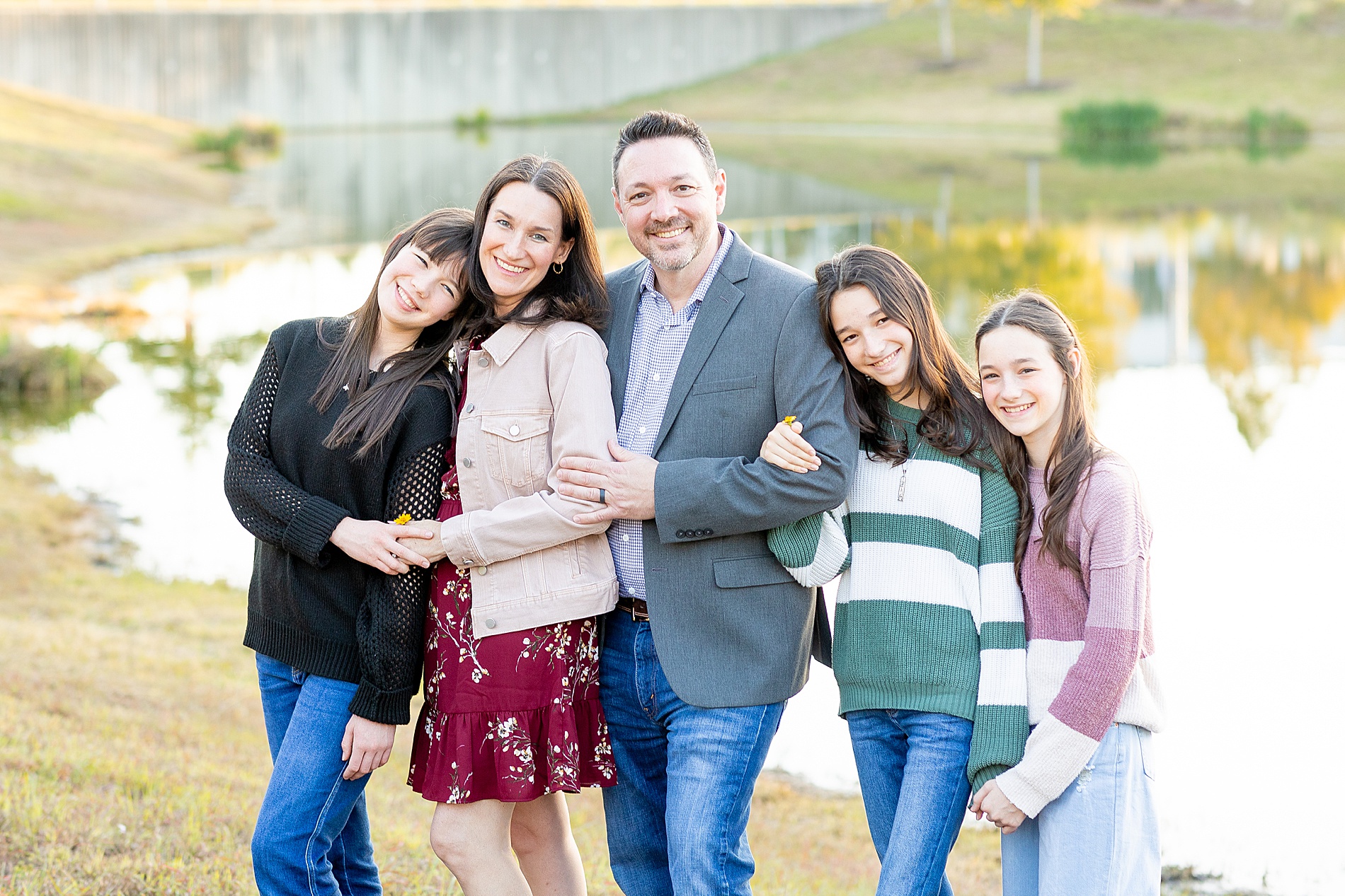 family of five stands by pond at City Place in The Woodlands, Texas