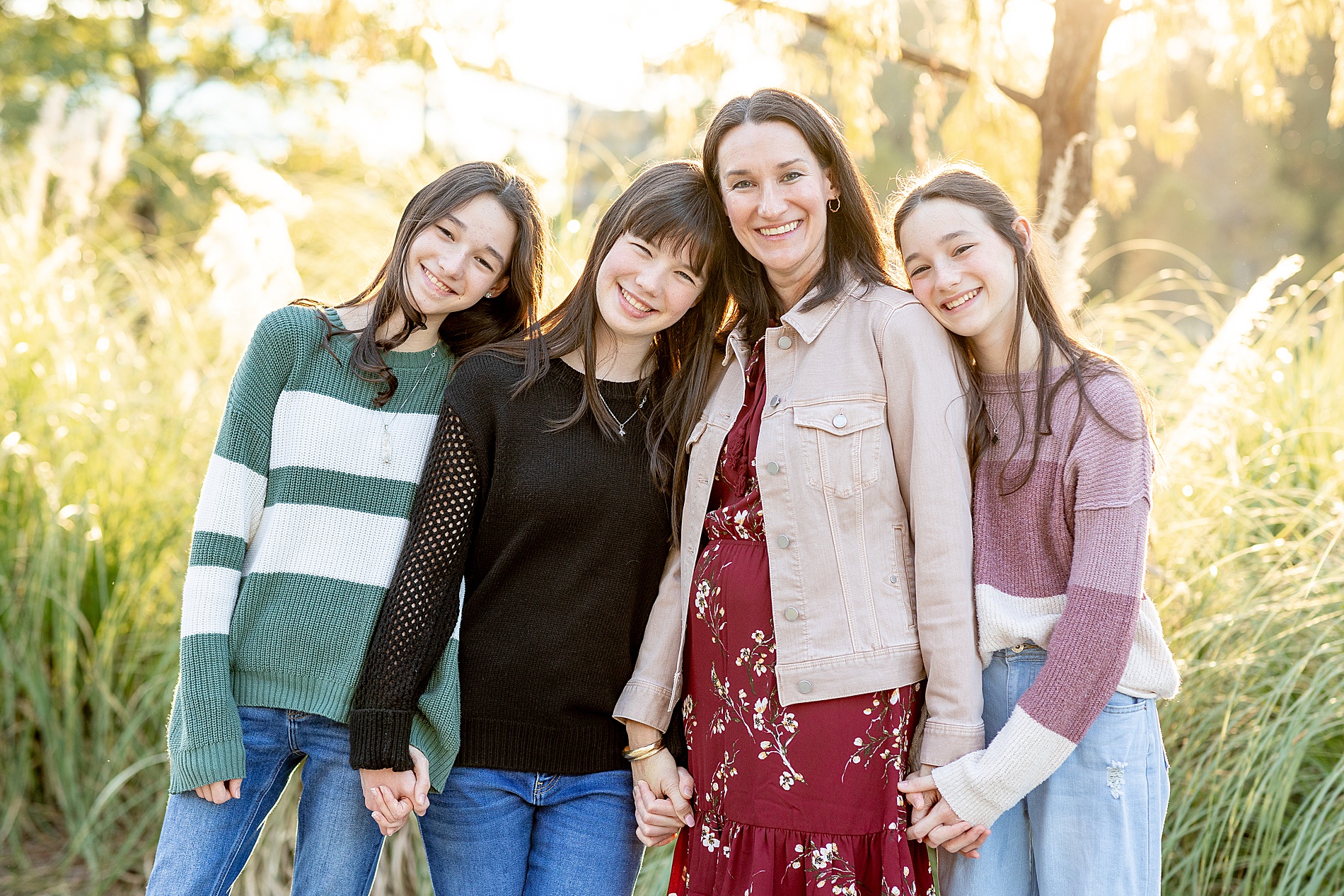 mom holds hands with her daughters during Texas Family Session at City Place in The Woodlands