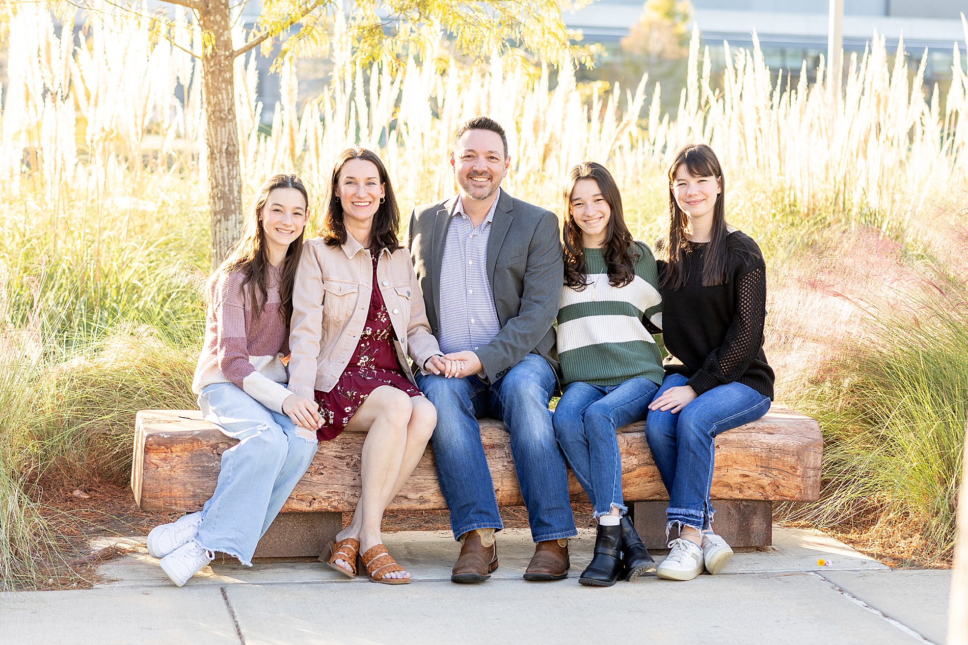 family of five sit together on bench