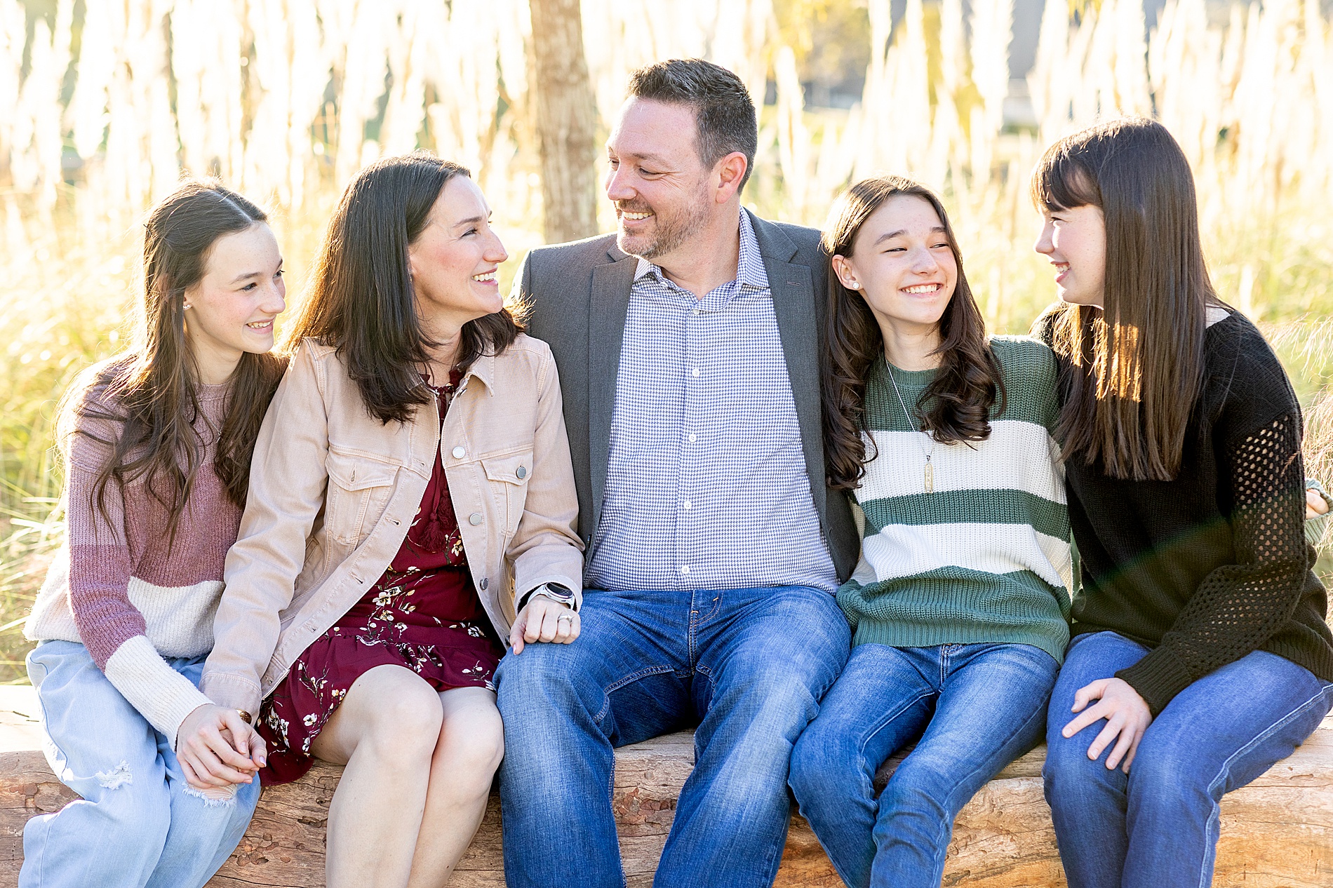 parents sit with their three daughters