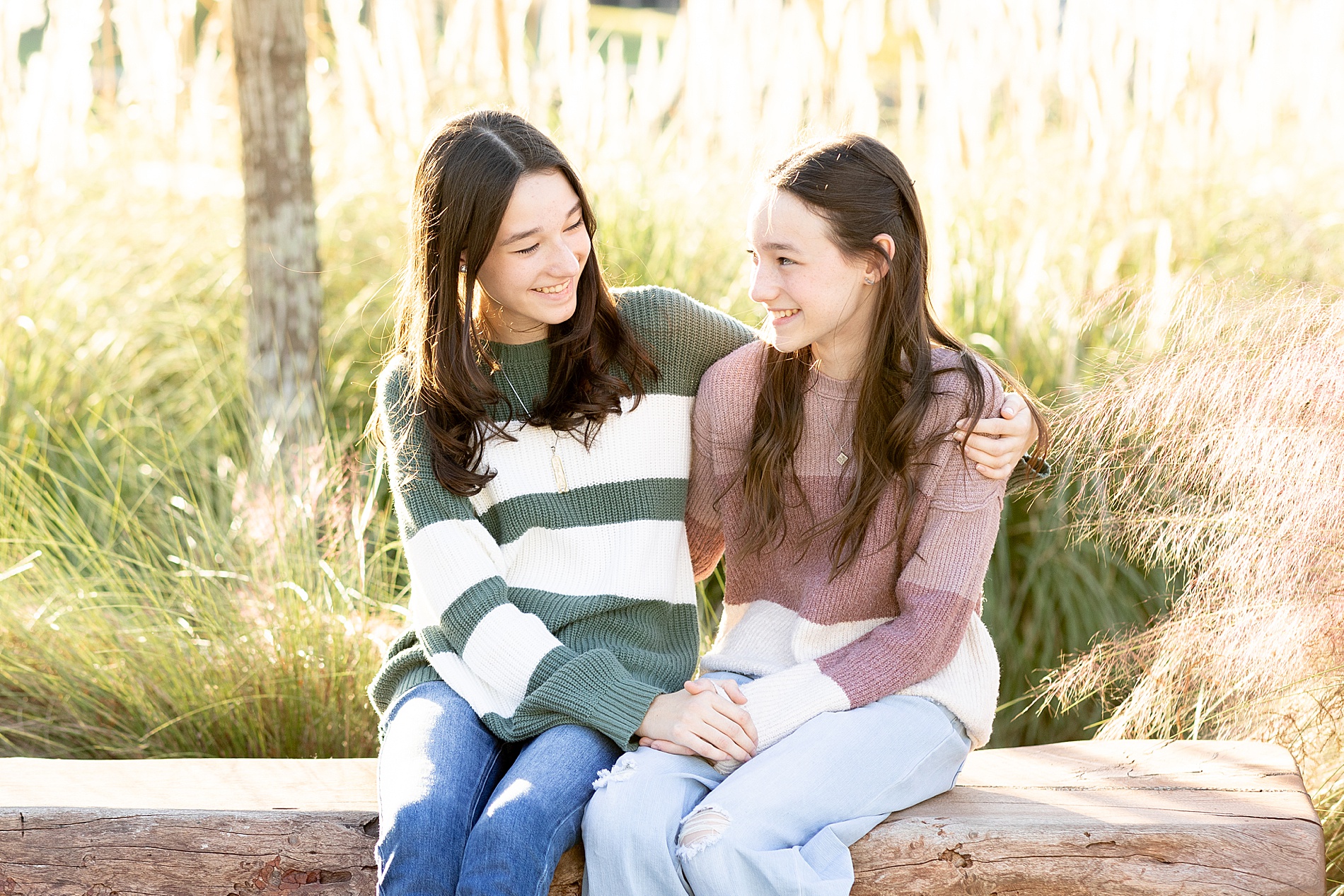 two sisters sit together on bench