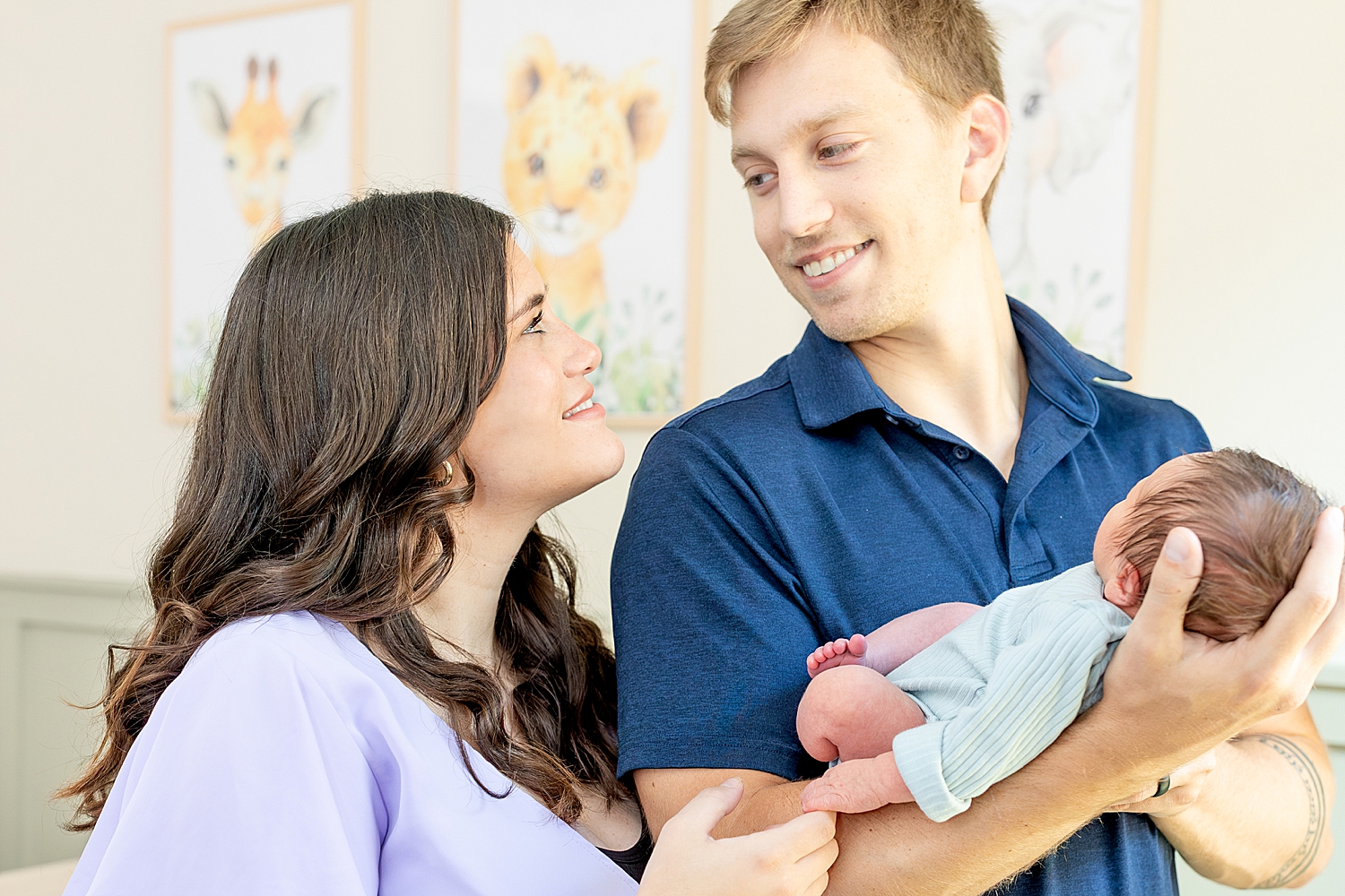 parents look at each other as they hold newborn