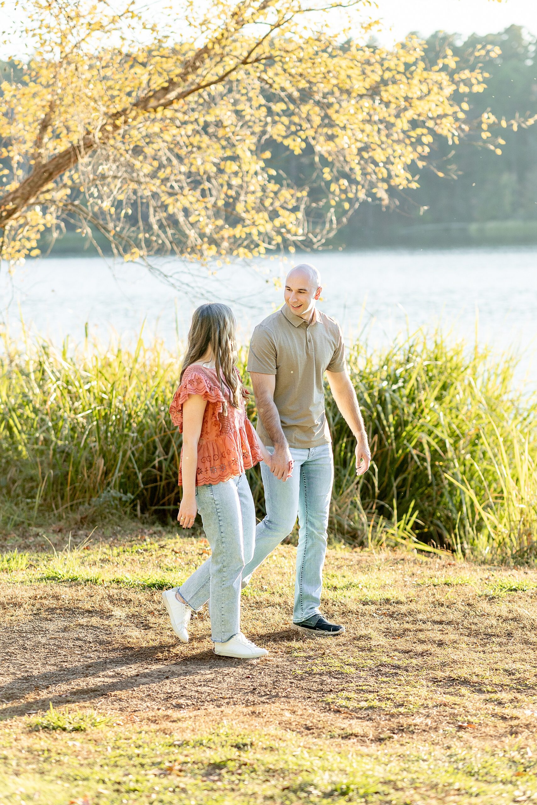 couple hold hands as they walk together 