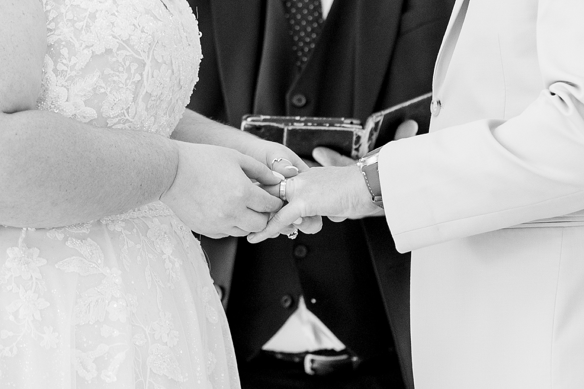 bride putting ring on groom's finger 