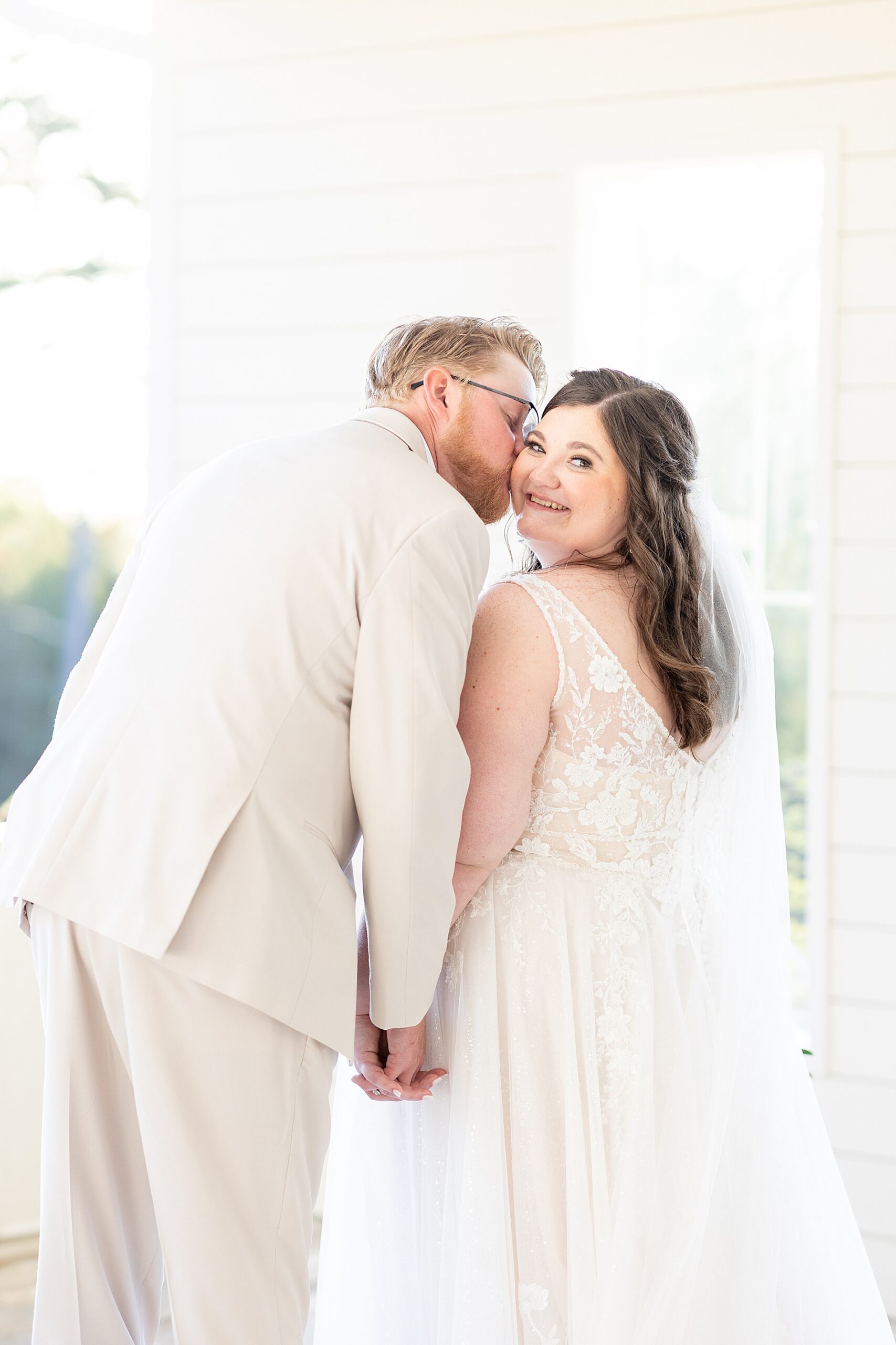 groom kisses bride's cheek