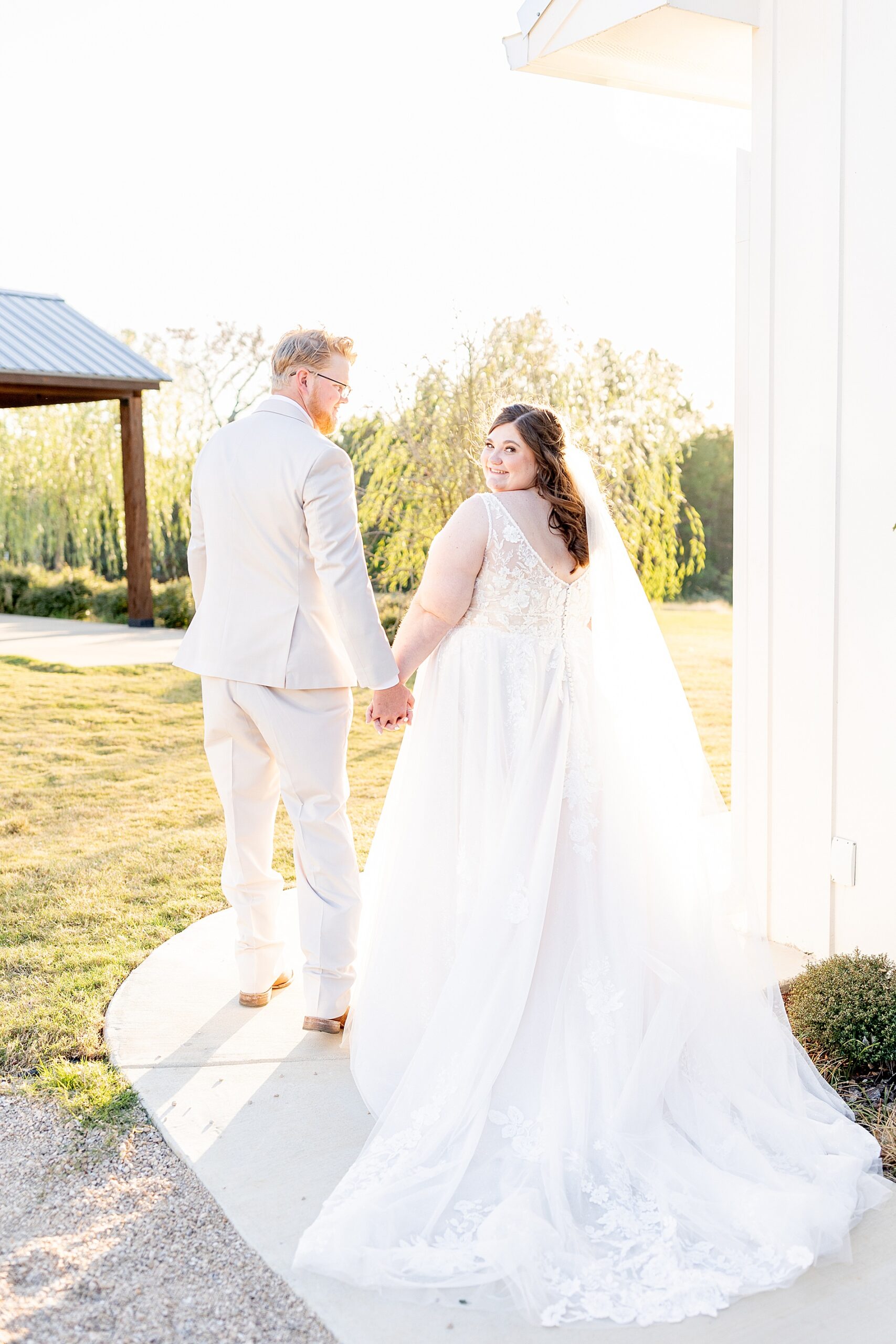 bride and groom hold hands as they walk together 