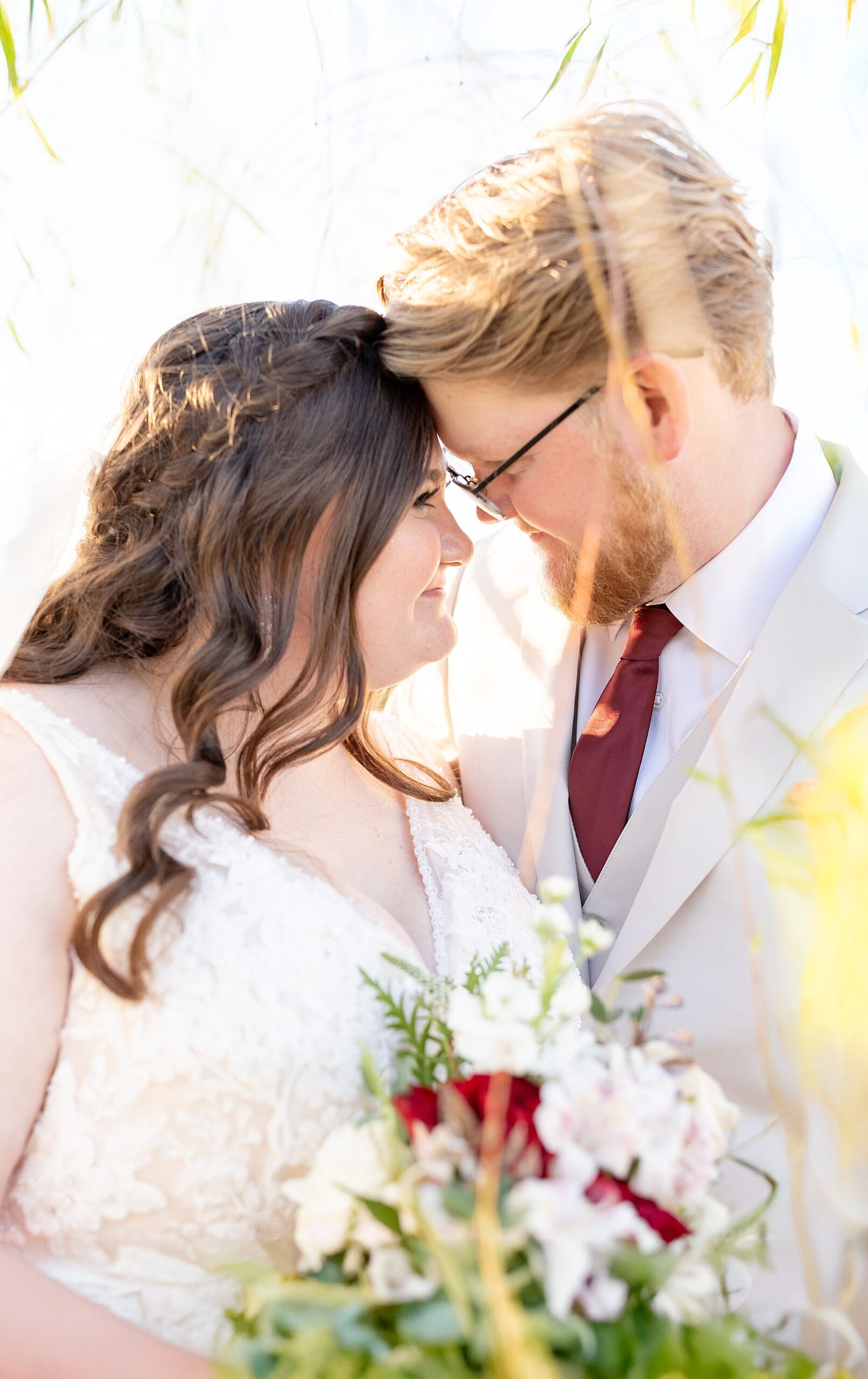 couple put heads together and lean in during wedding photos