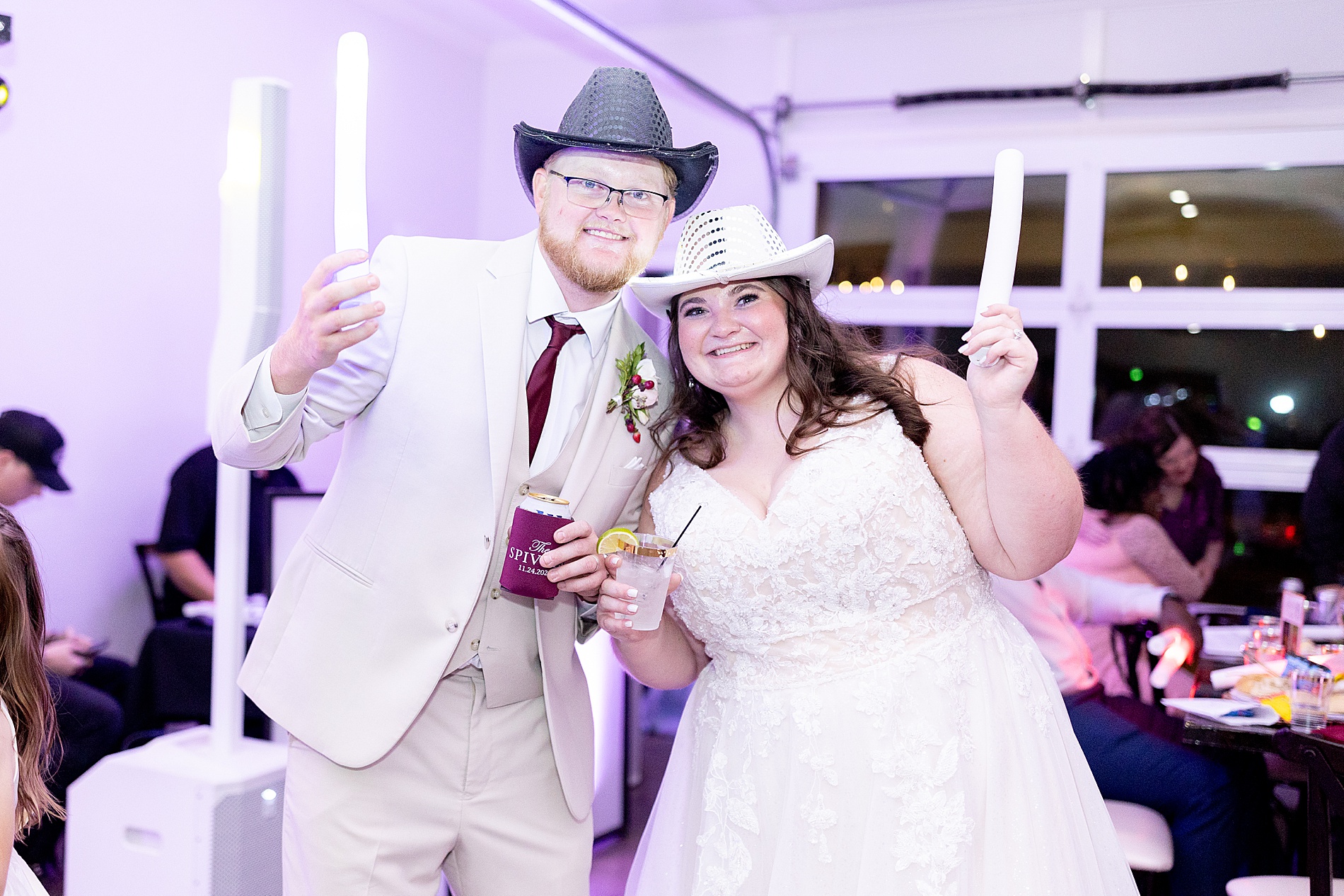 newlyweds at wedding reception with glow sticks and cowboy hats