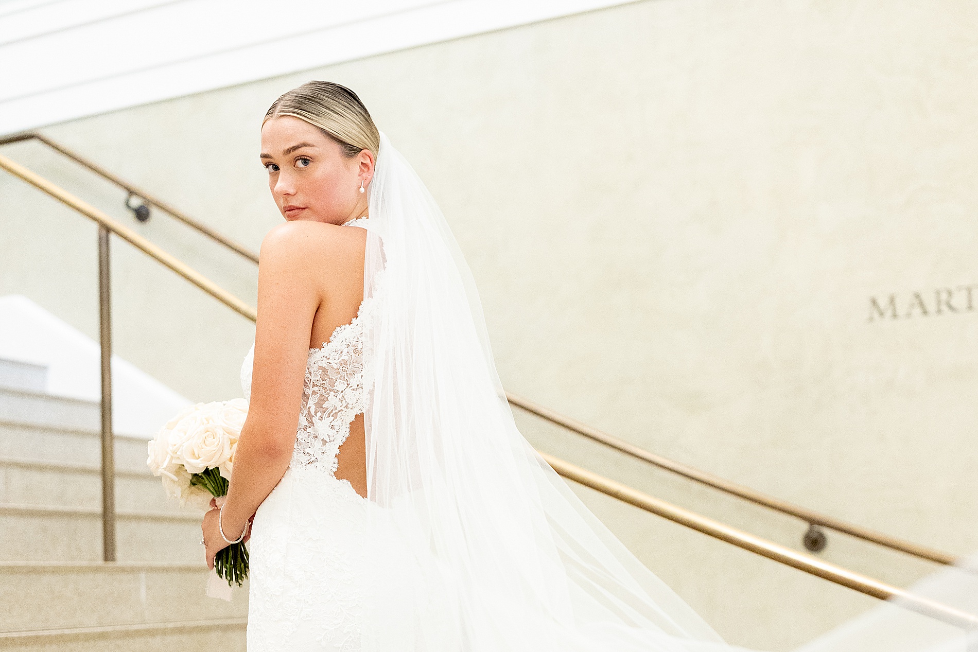 bride turns head over shoulder with veil behind