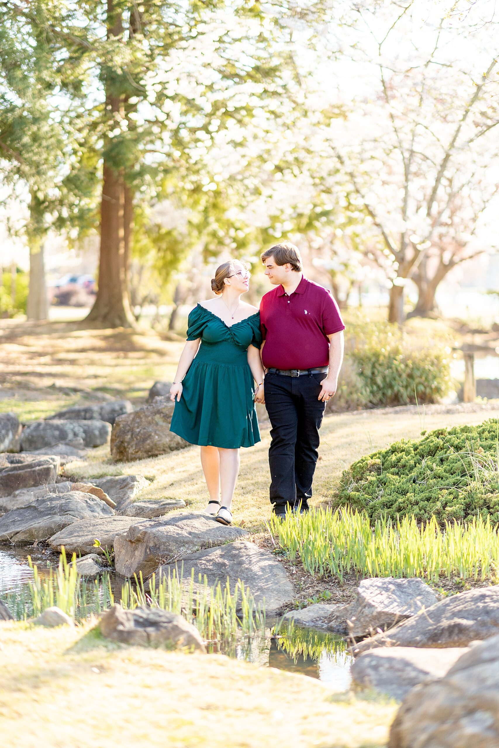 couple walk hand in hand during spring engagement shoot