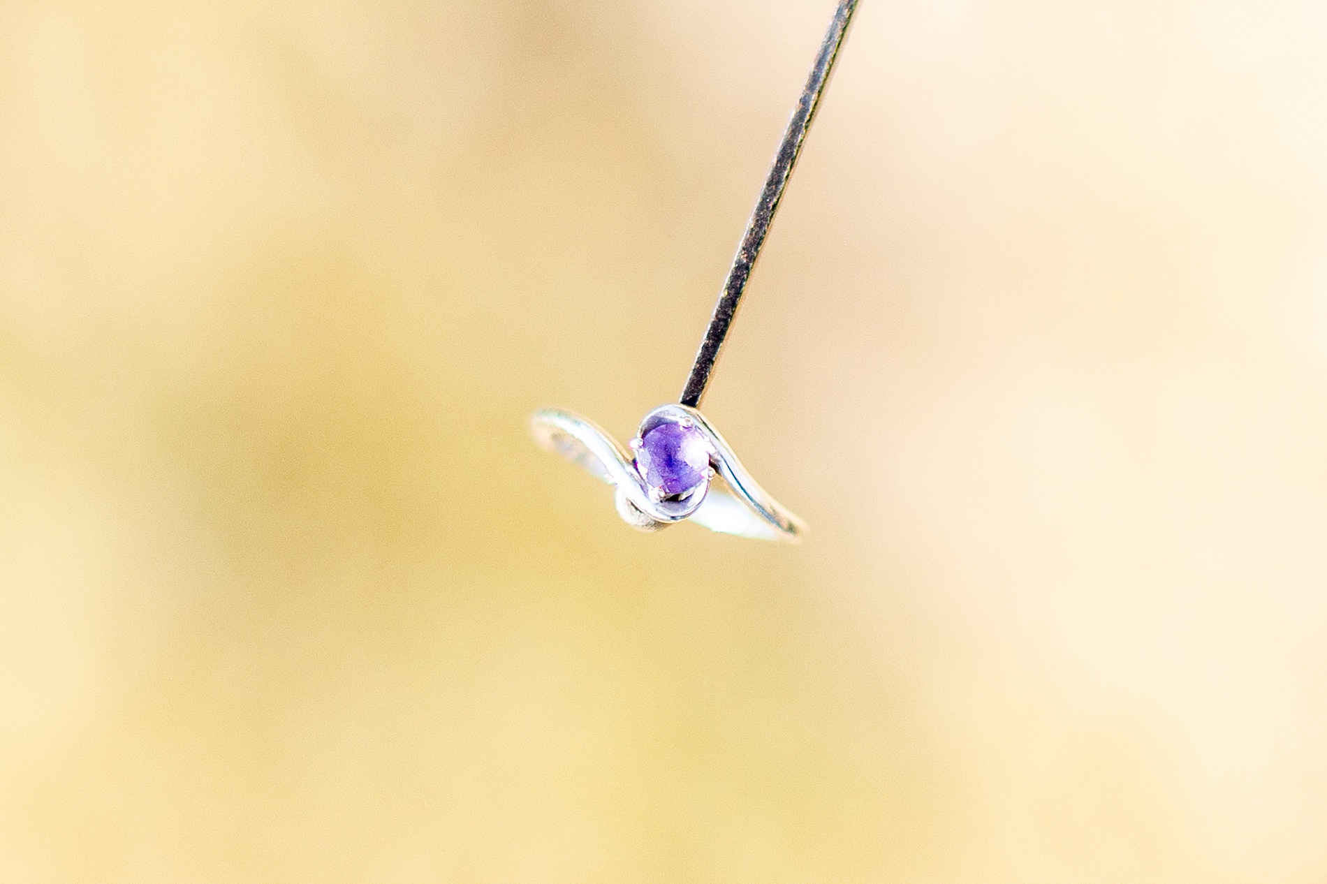 purple stone engagement ring on tip of sword