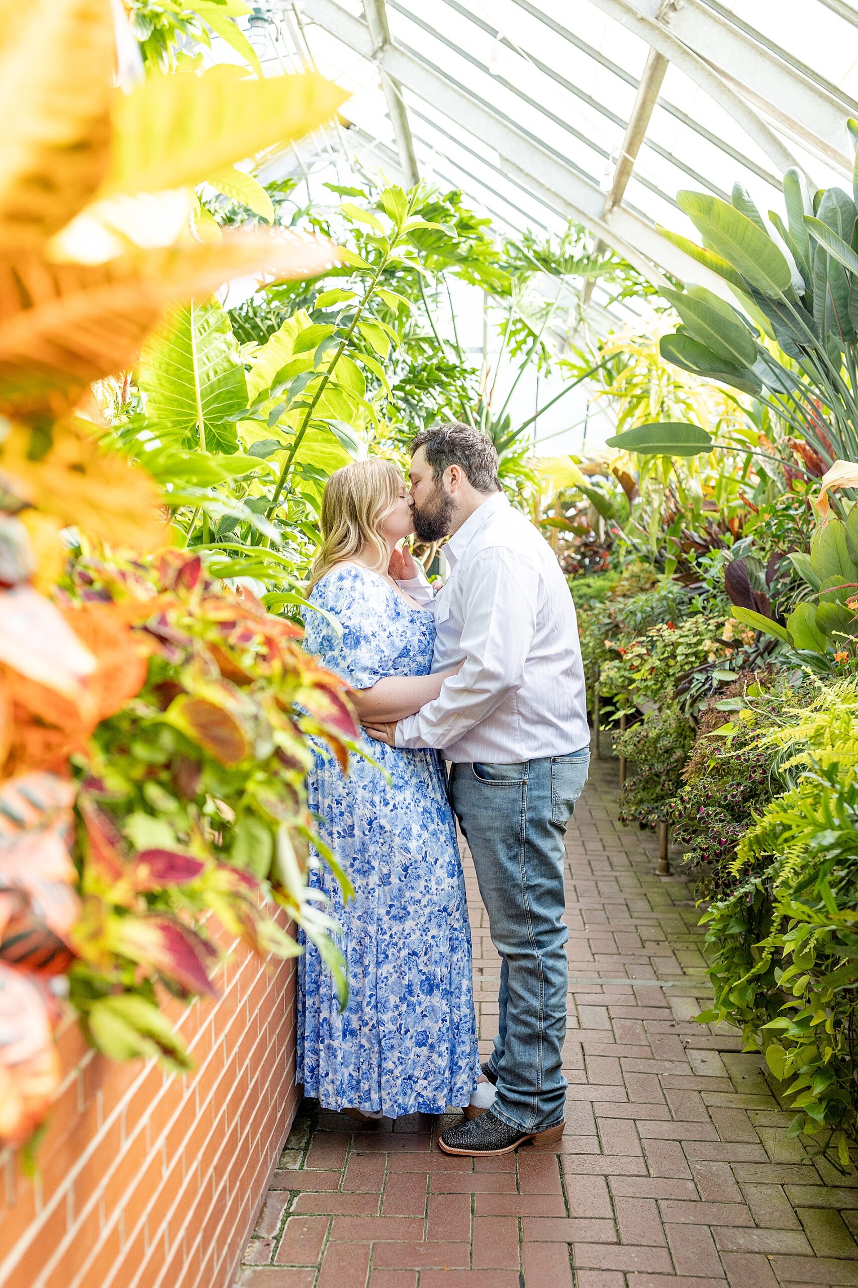 couple kiss inside greenhouse