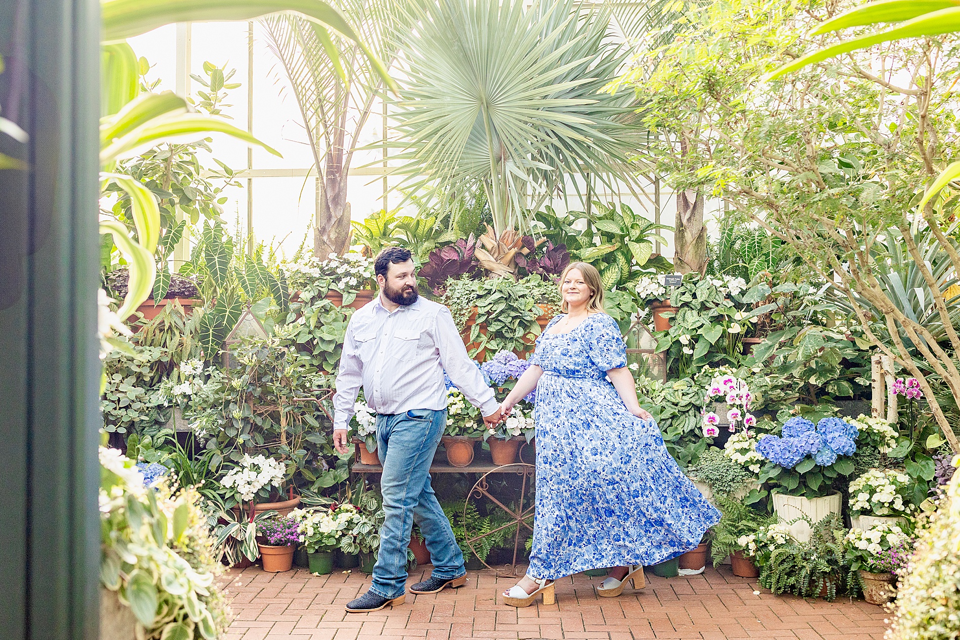 guy leads fiancé through greenhouse