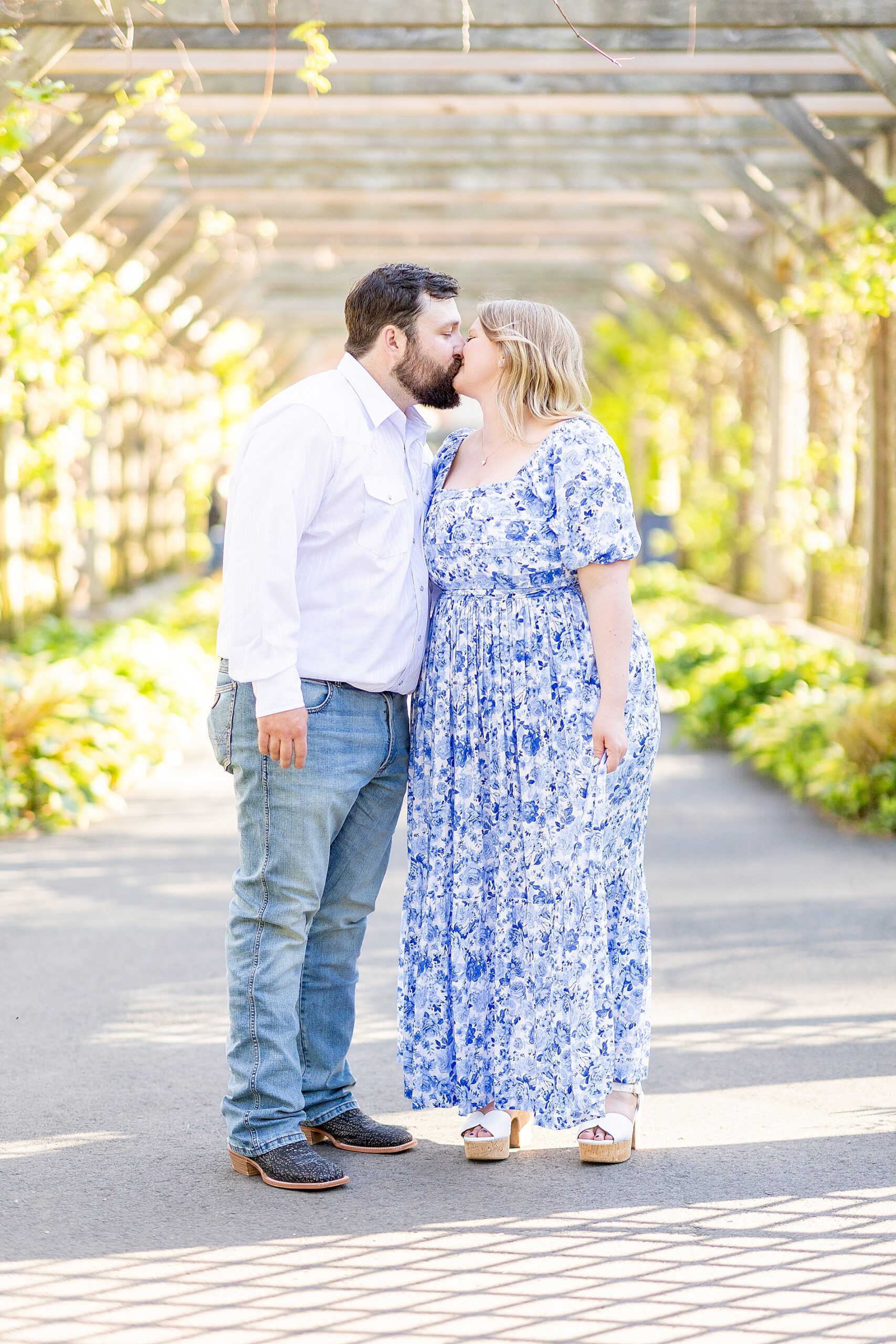 couple kiss under pergola