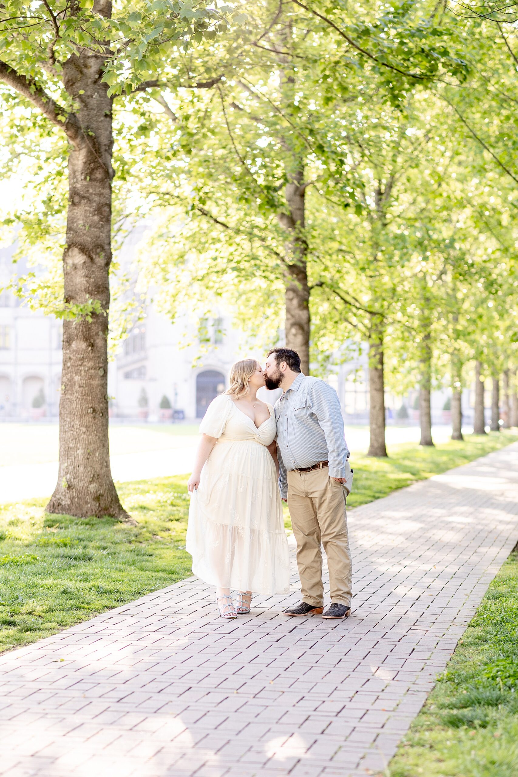 couple kiss path lined with trees