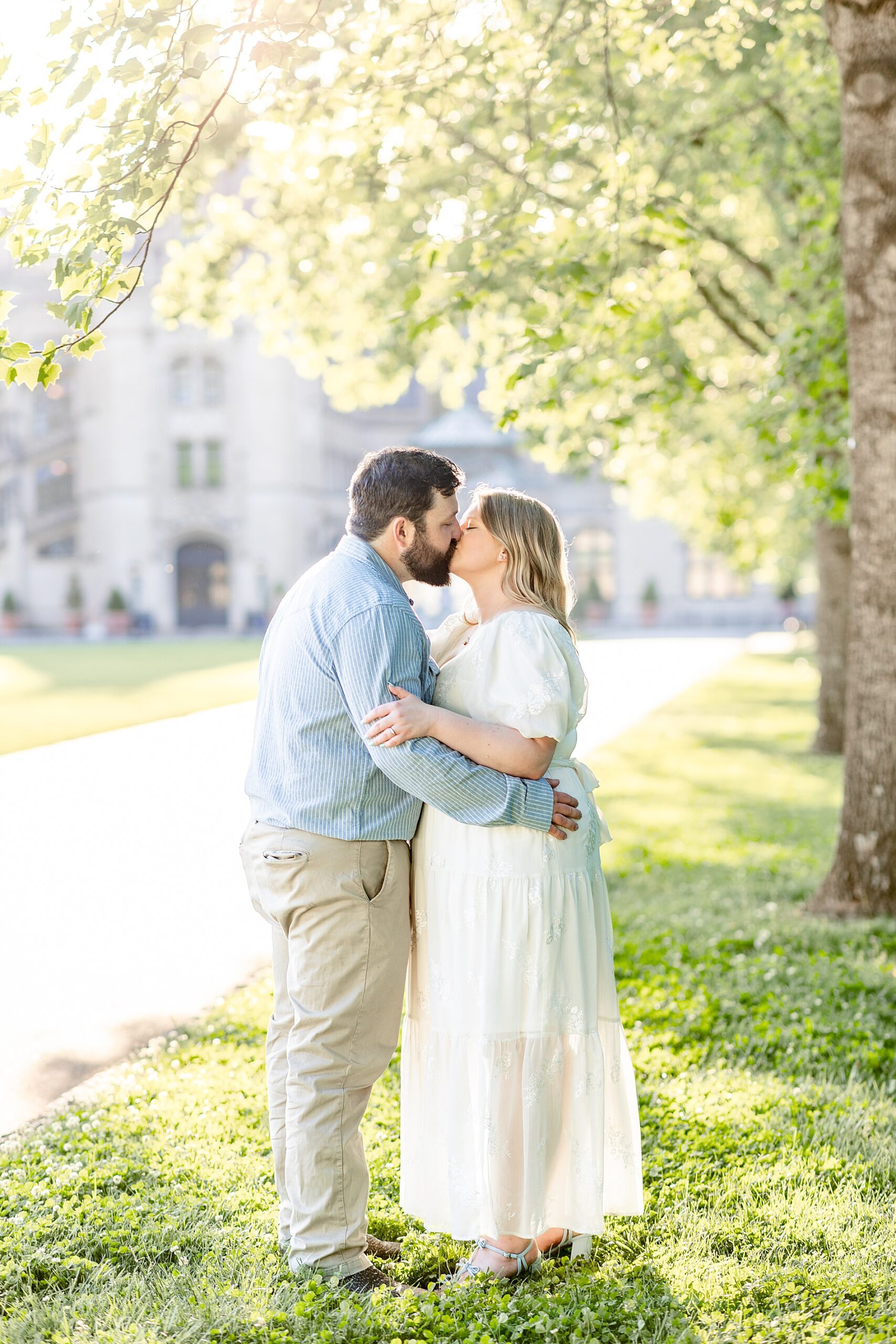 couple kiss under tree by Biltmore Estate in Asheville, NC