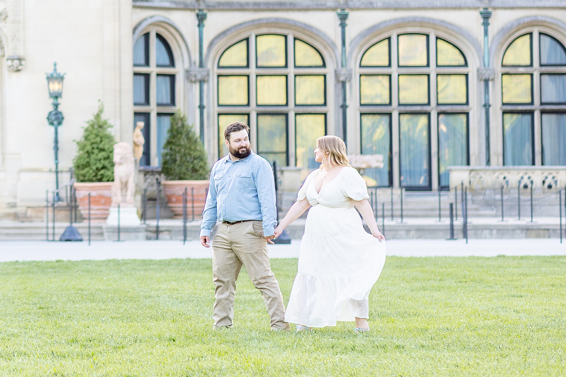 couple walk on the lawn of Biltmore Estate