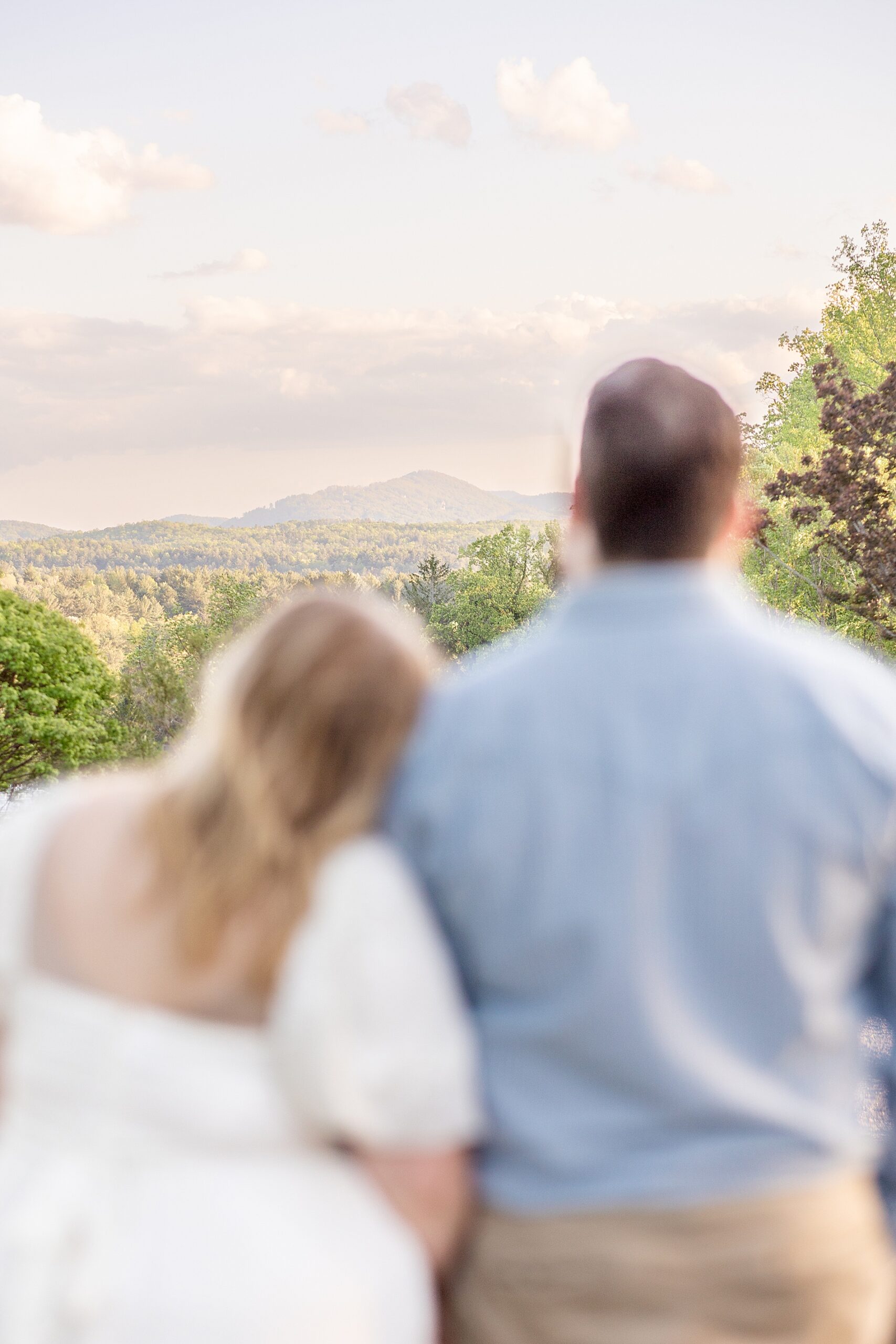 engaged couple look out at view of mountains in Asheville, NC