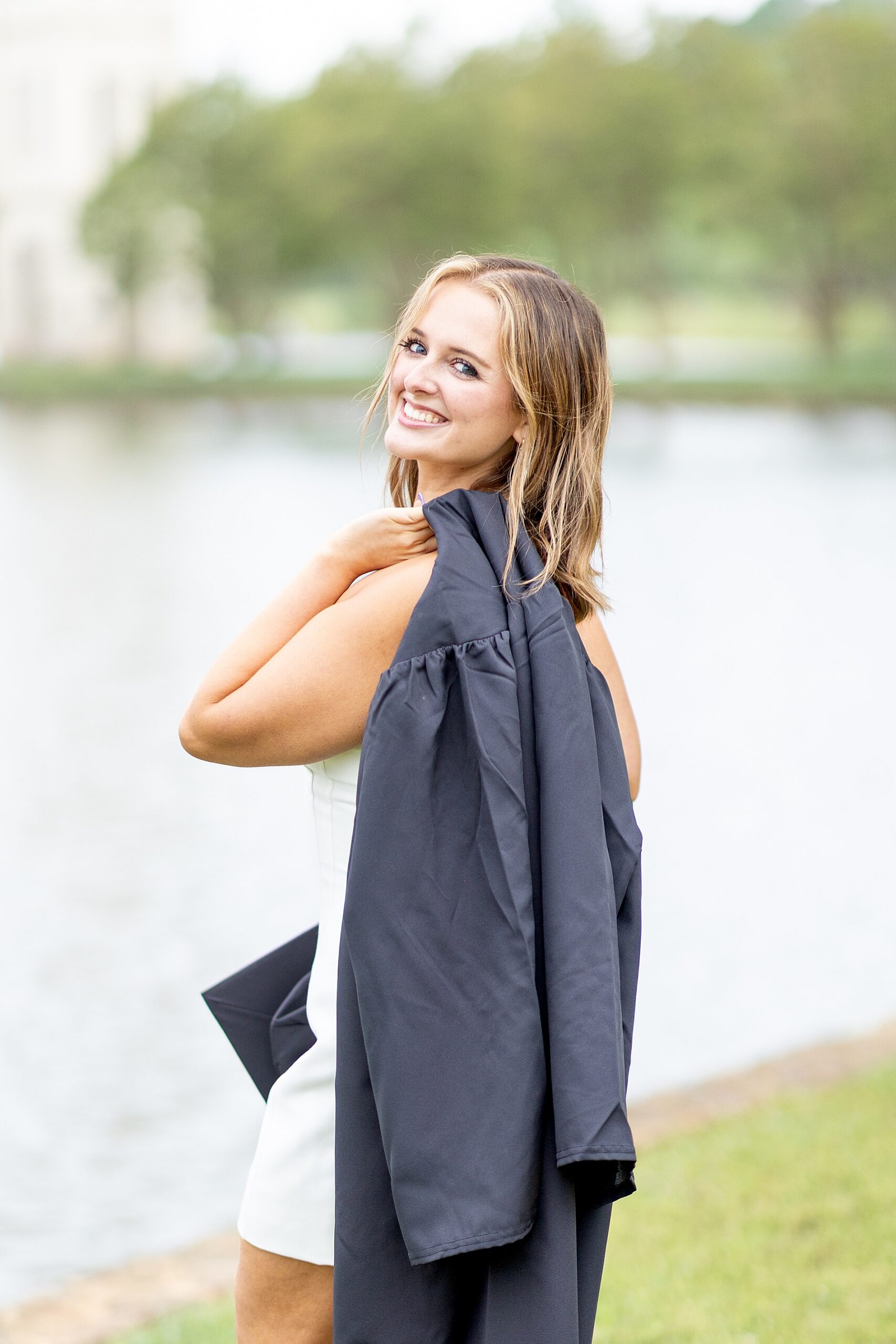 woman holds cap and gown during senior session at Furman University