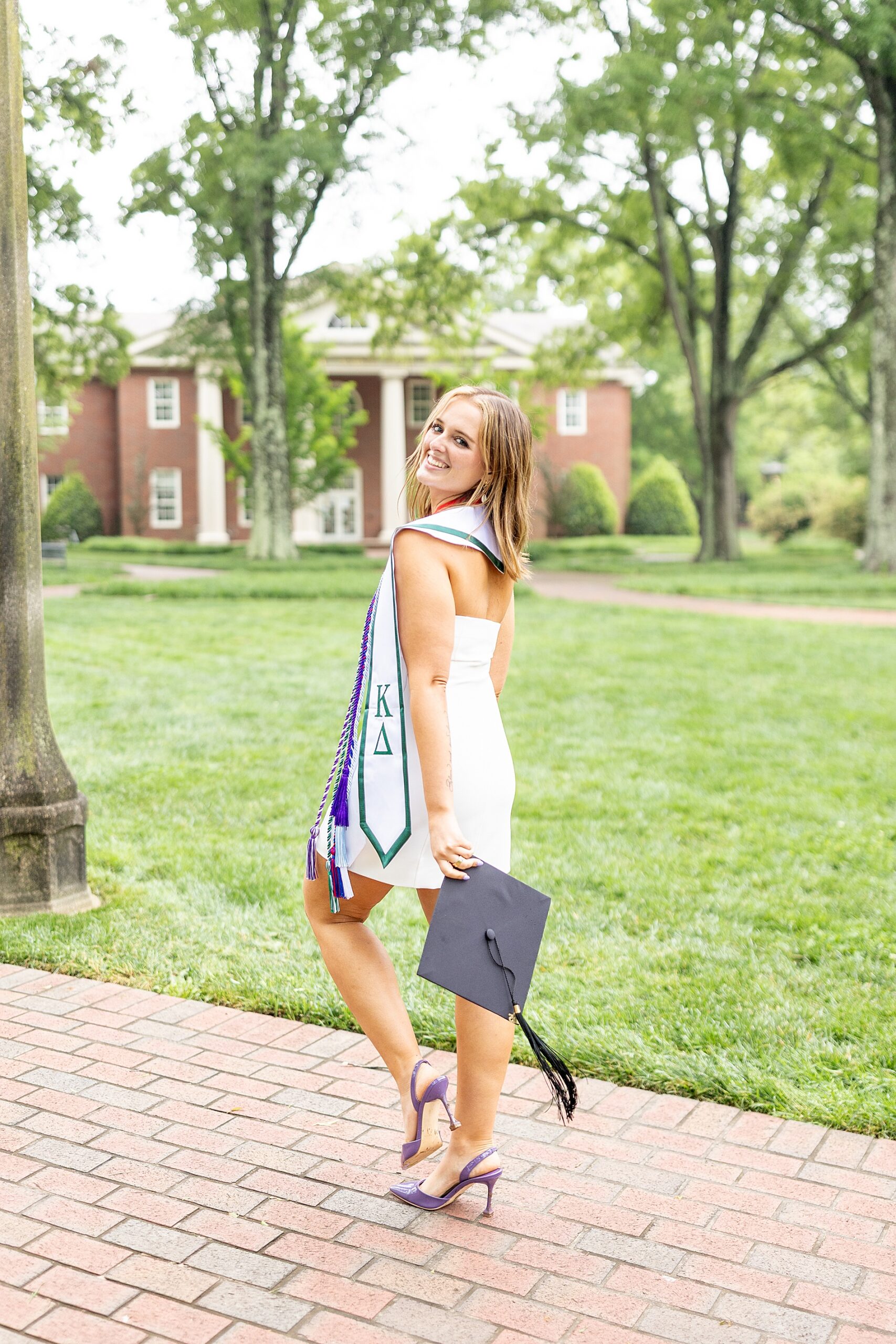 college graduate walk along brick sidewalk