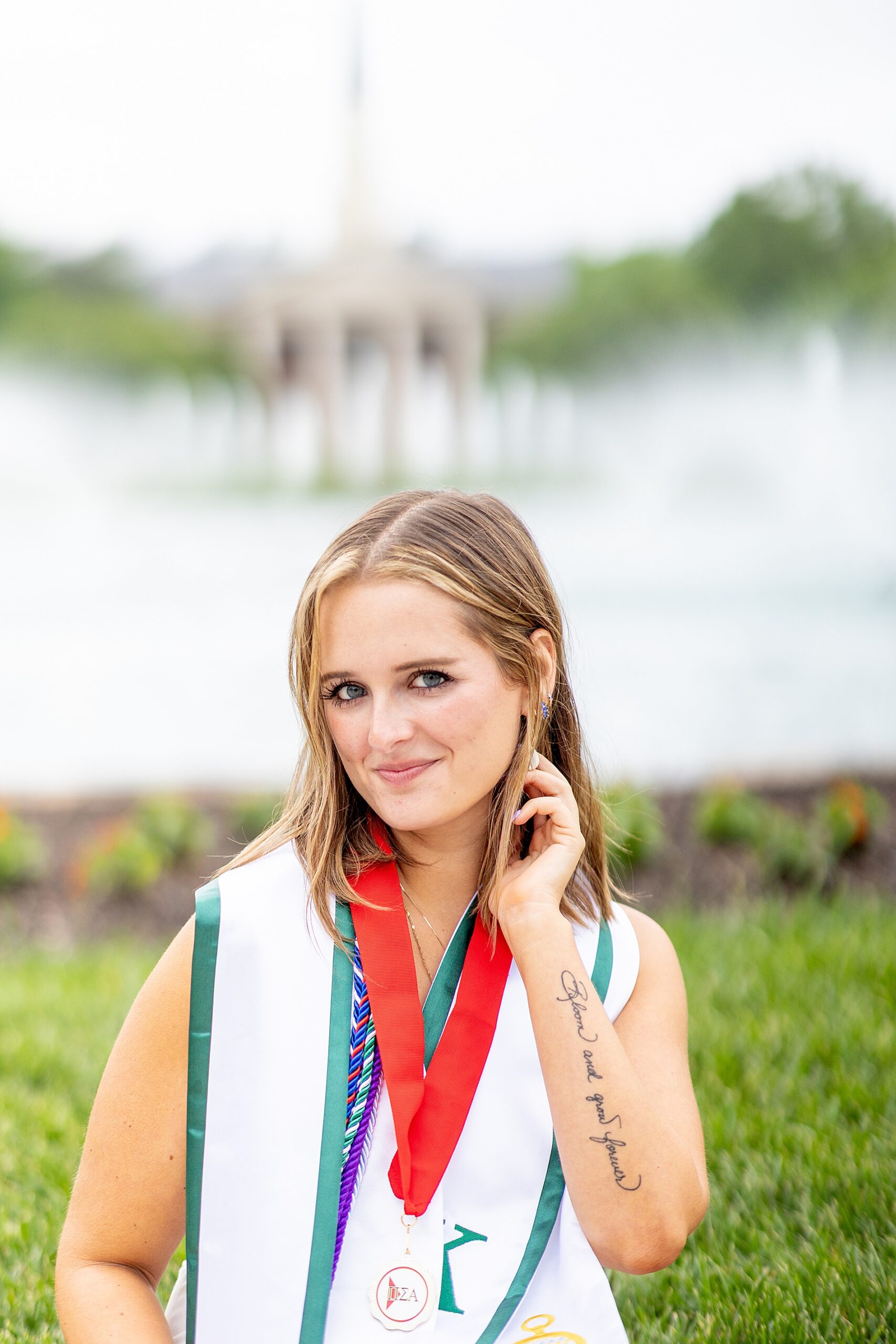 woman wearing college cords and sits in front of fountain