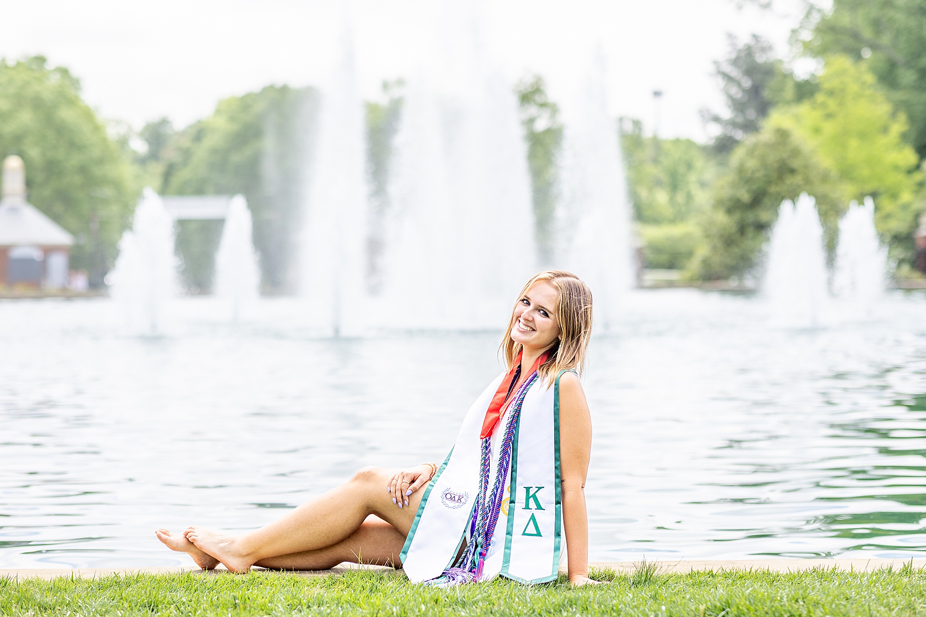 senior sits by fountain