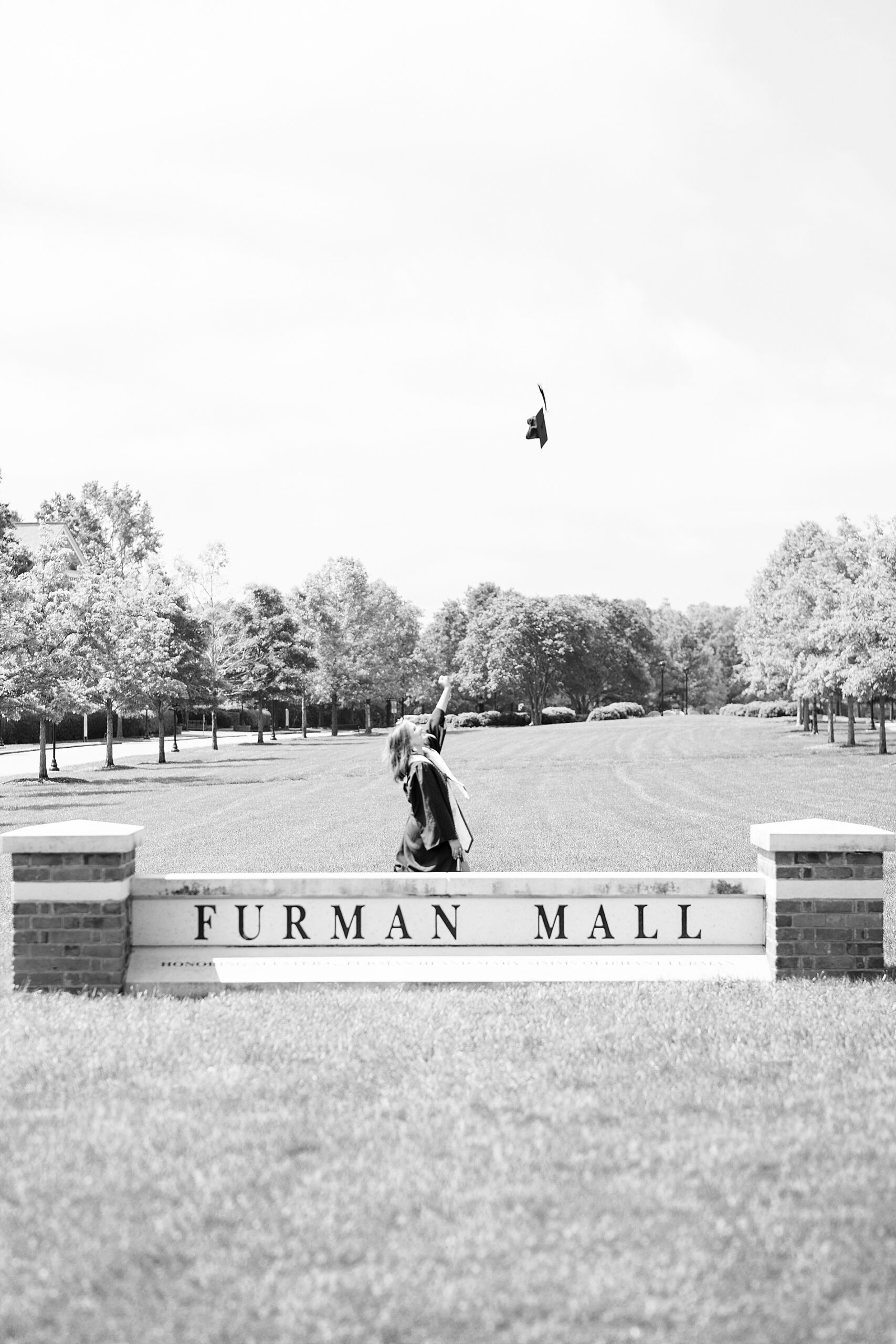 college graduate tosses graduation cap in the air