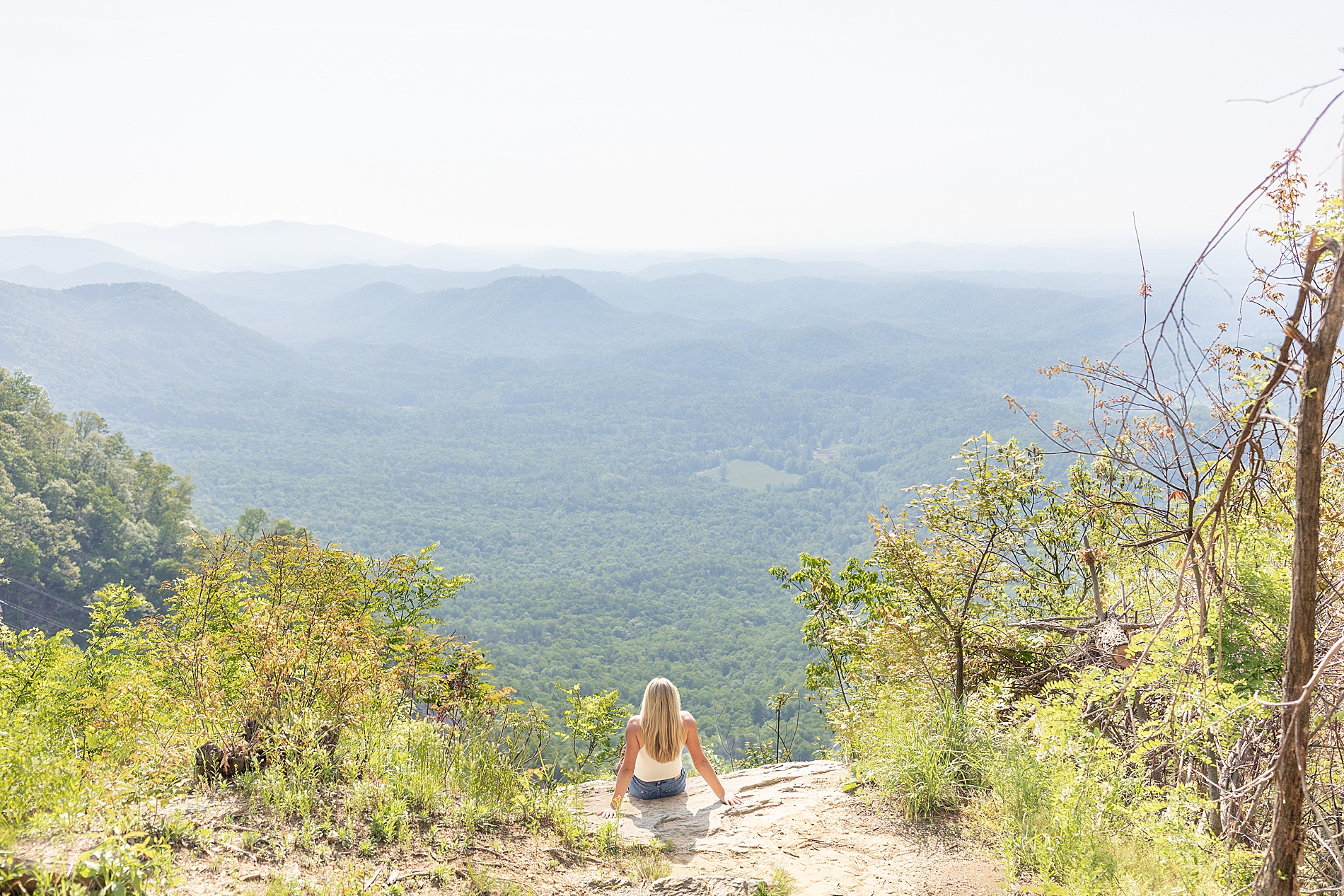 girl sits on ledge and looks out at the mountain views in Greenville, SC at Pretty Place Chapel