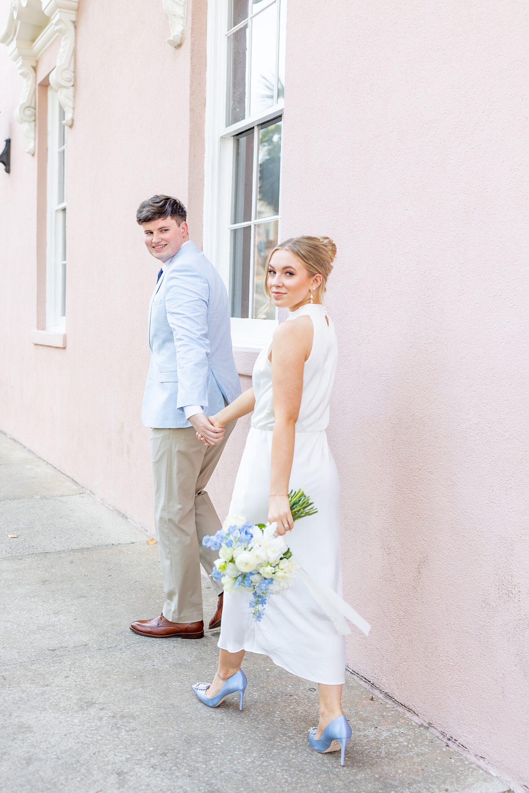 guy leads fiancé down the sidewalk holding hands