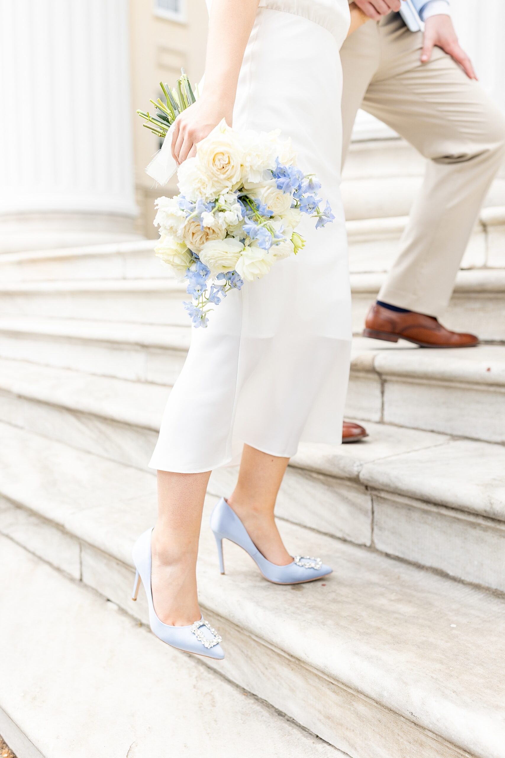 woman's blue shoes and soft floral bouquet