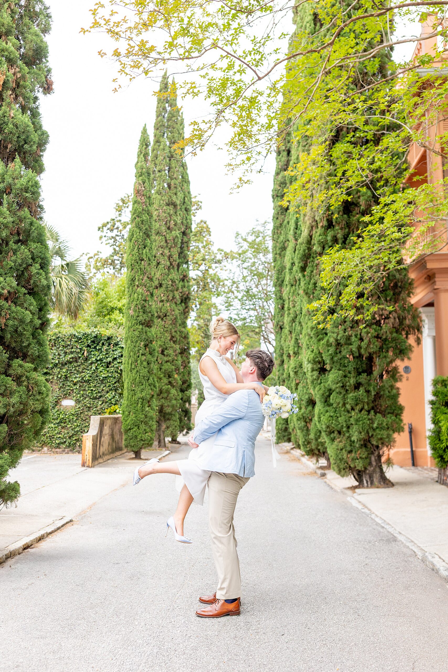 man lifts up his fiancé during Charleston engagement