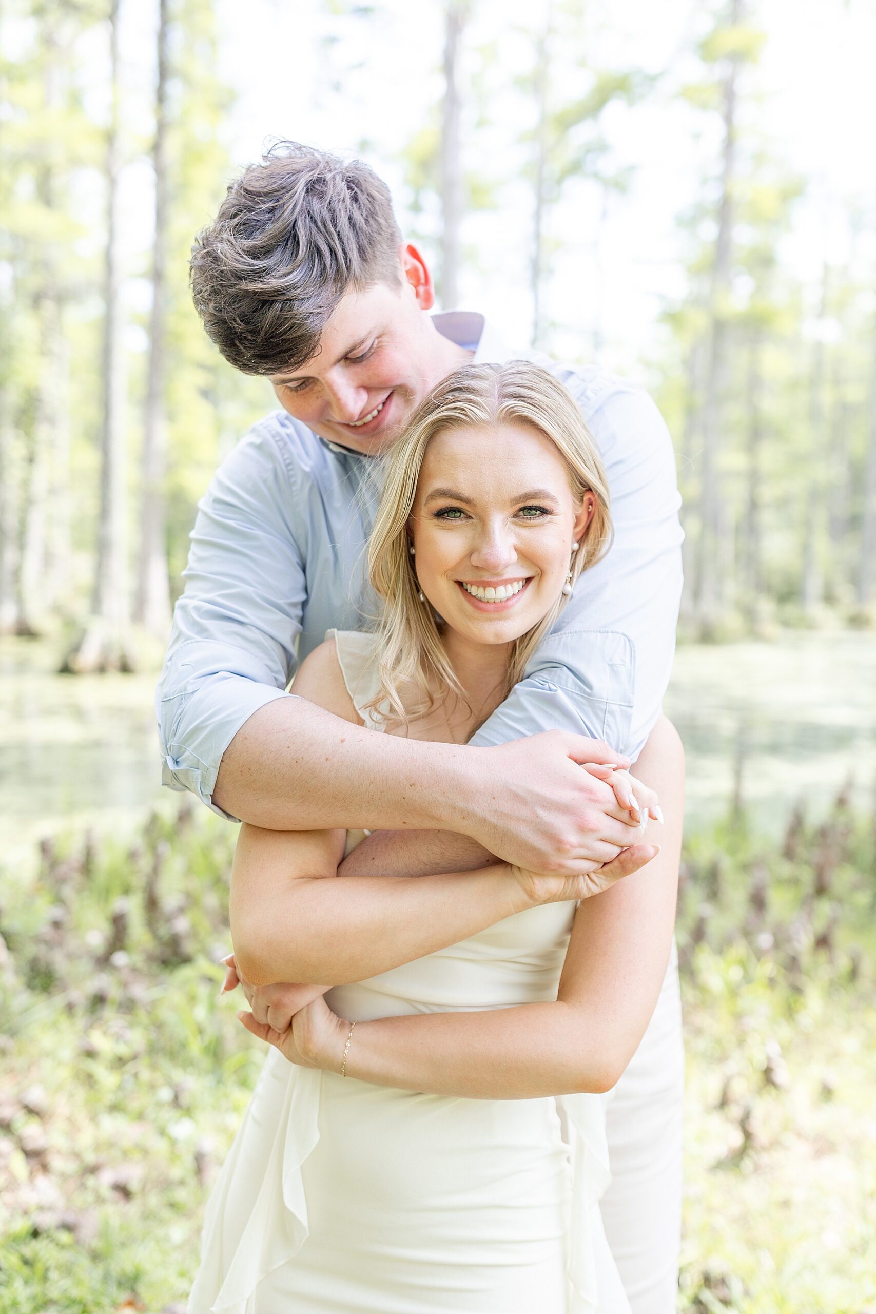 man wraps his arms around his fiancé