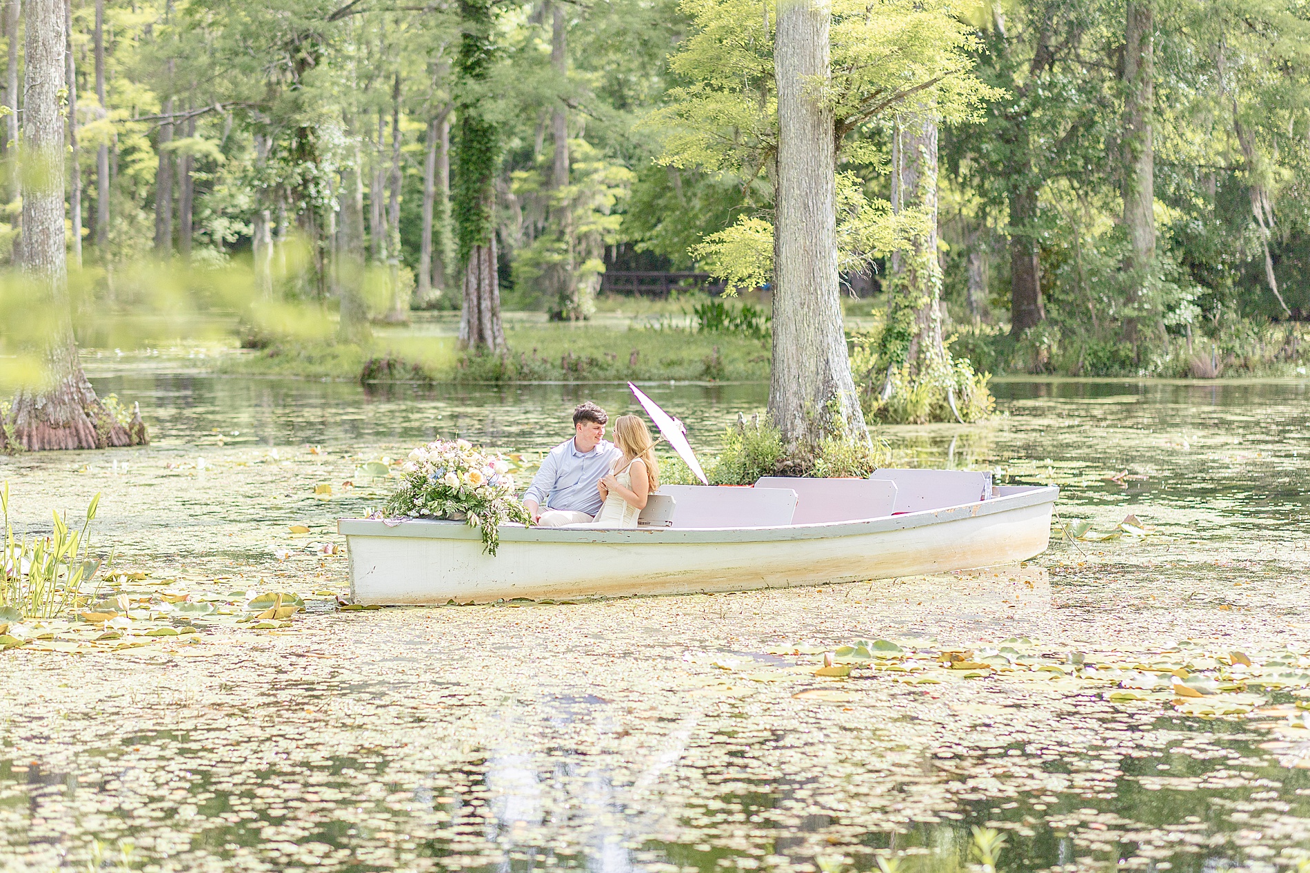 Romantic engagement photos of couple floating on water in boat