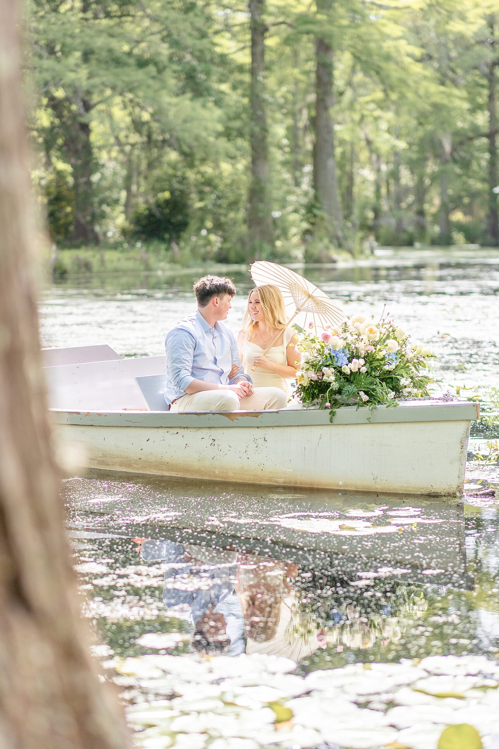 intimate engagement photo of couple floating on water in row boat