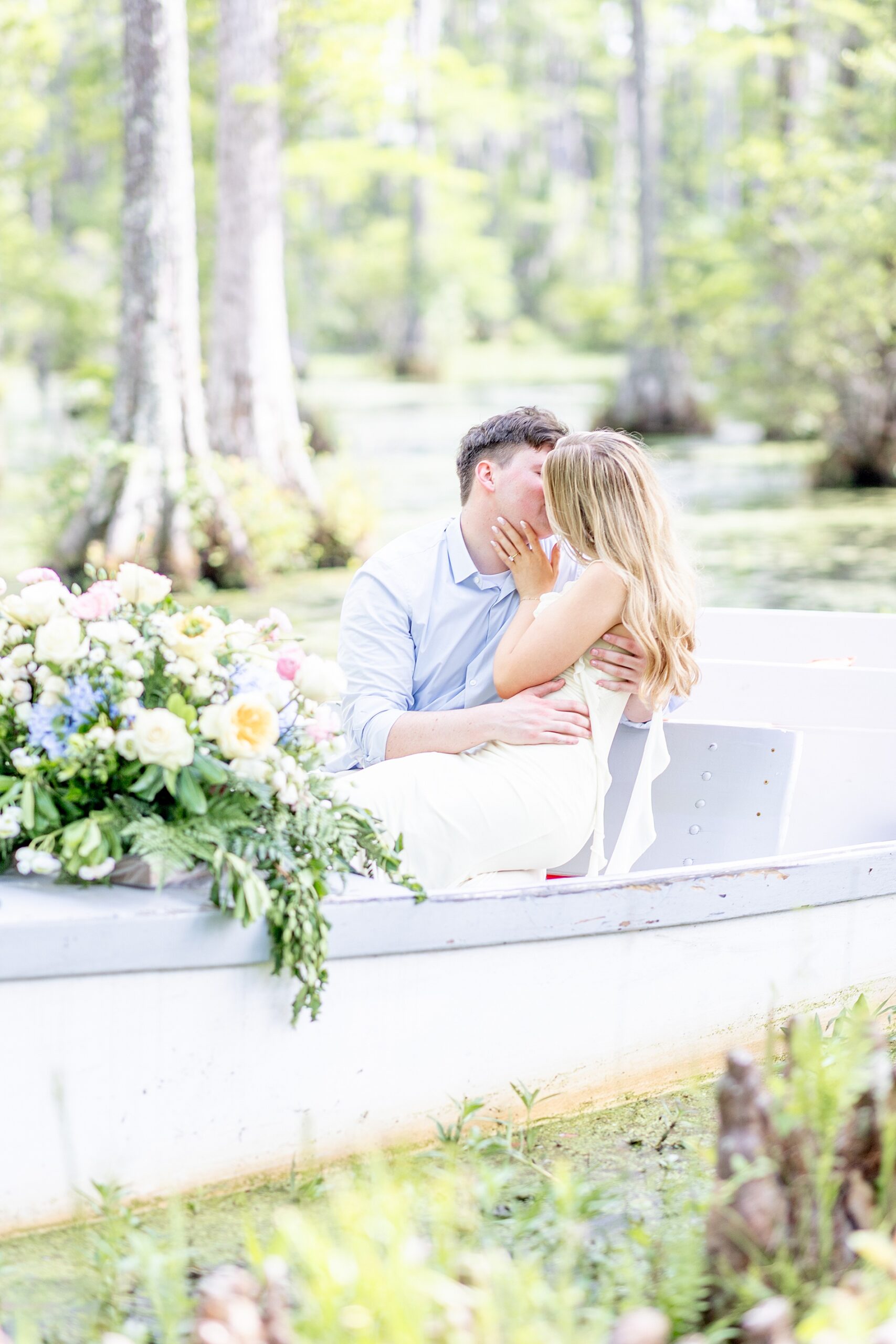 couple kiss on boat during light and airy Charleston engagement