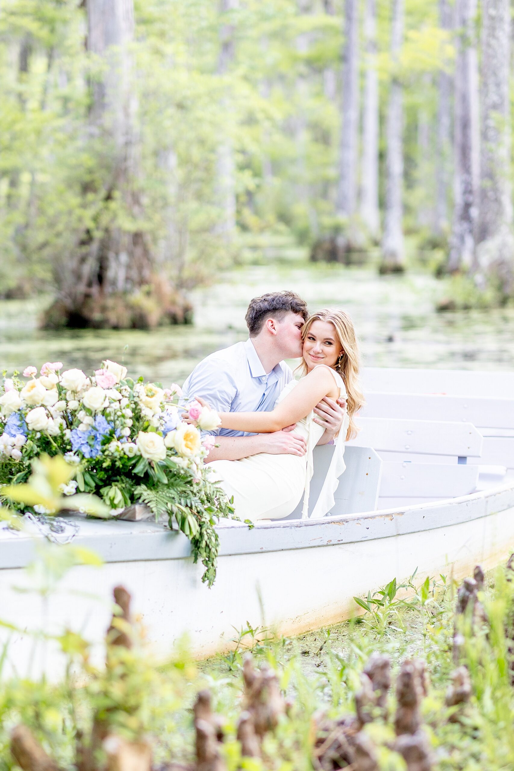 couple in boat floating on water at Cypress Gardens during romantic Charleston engagement
