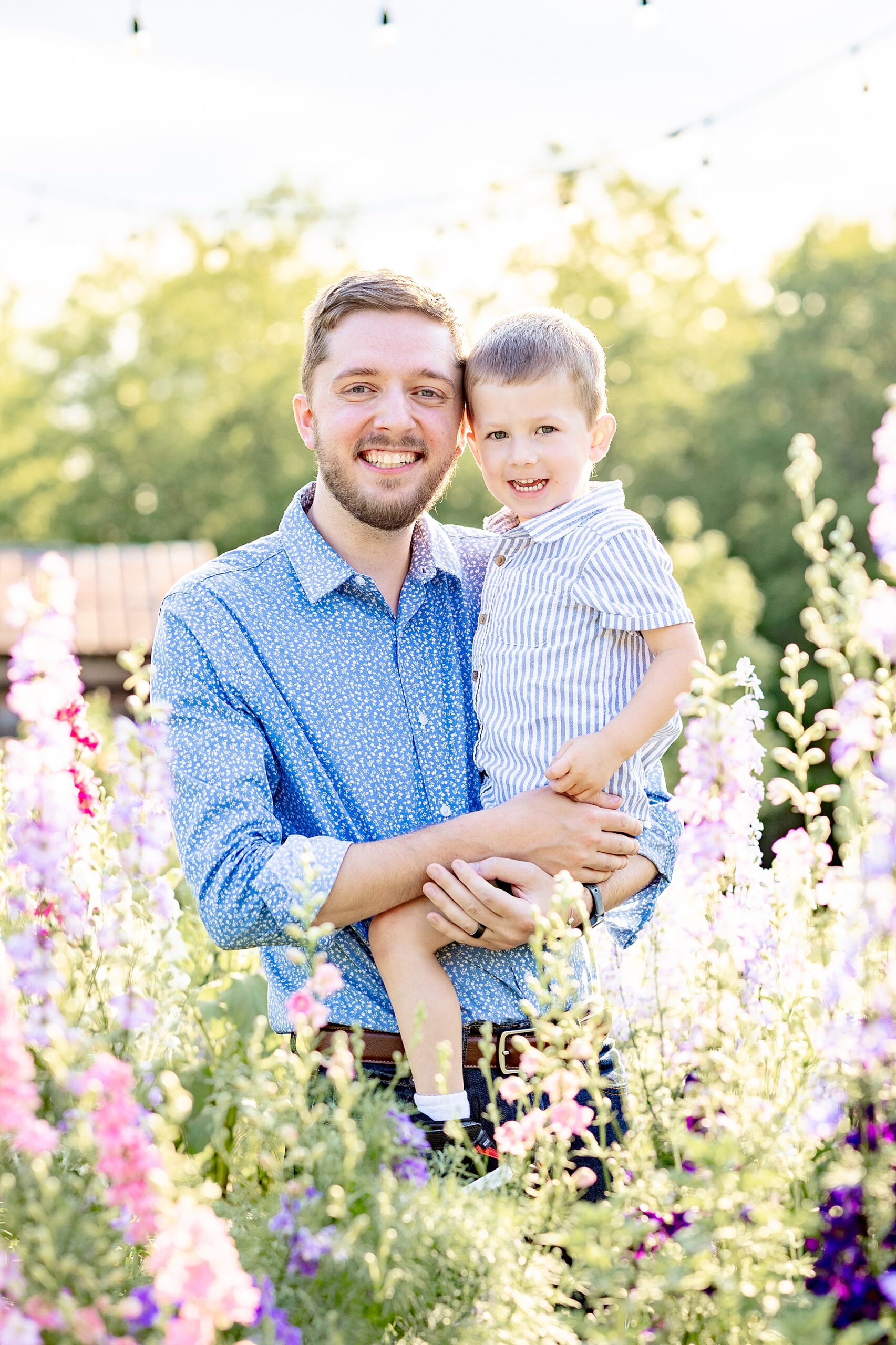dad holds son in field of flowers