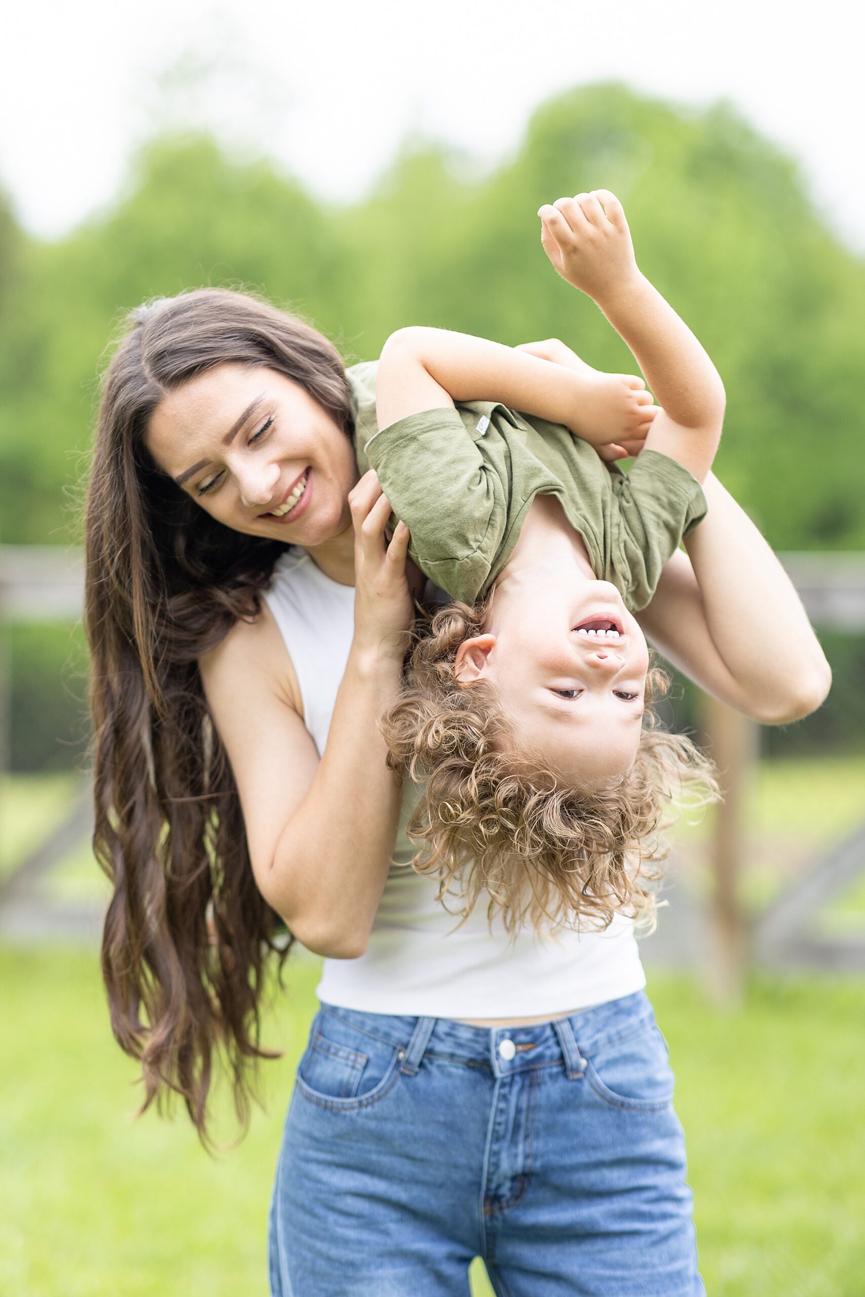 playful family photos of mom carrying son over shoulder