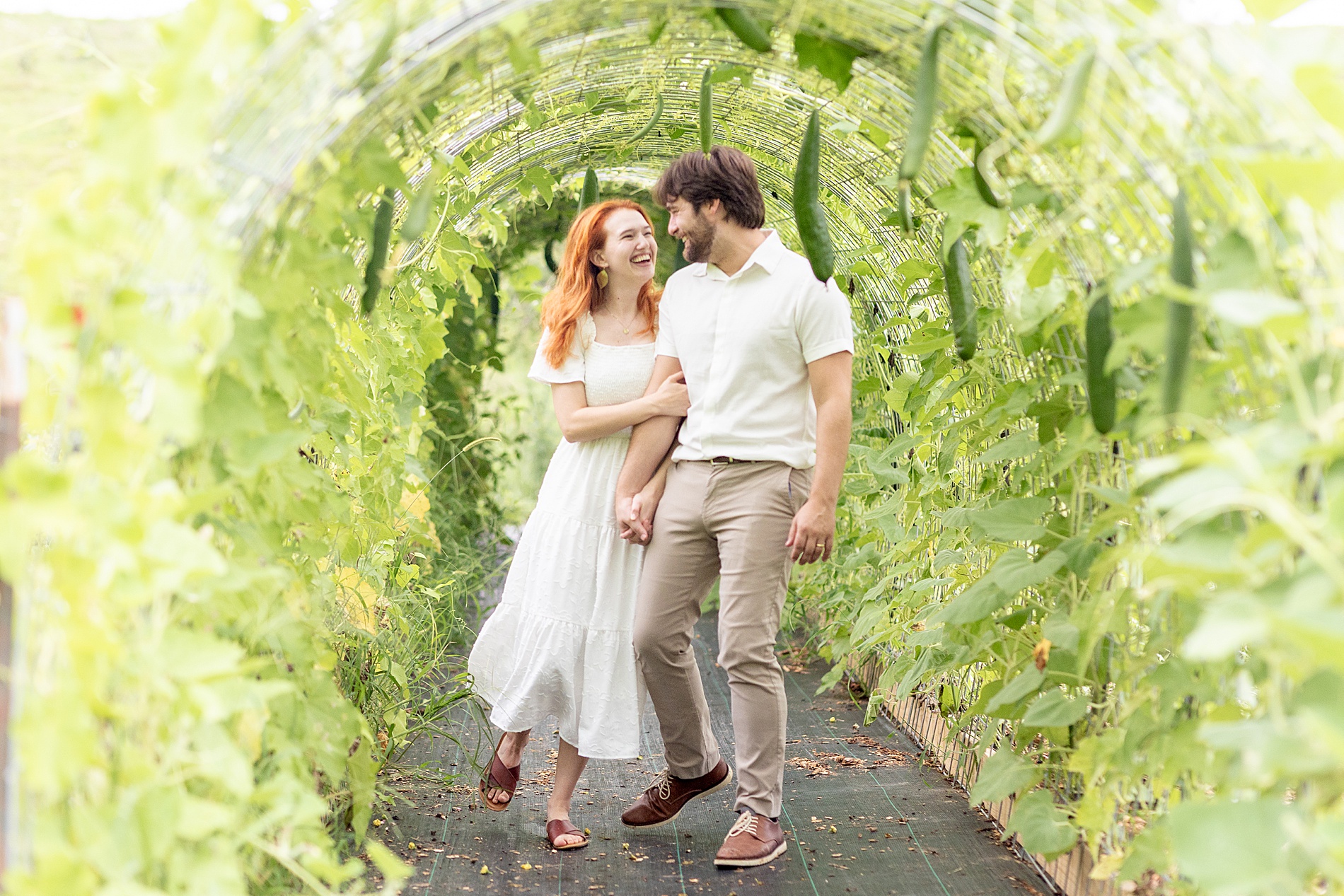 couple walk through tunnel of greenery 