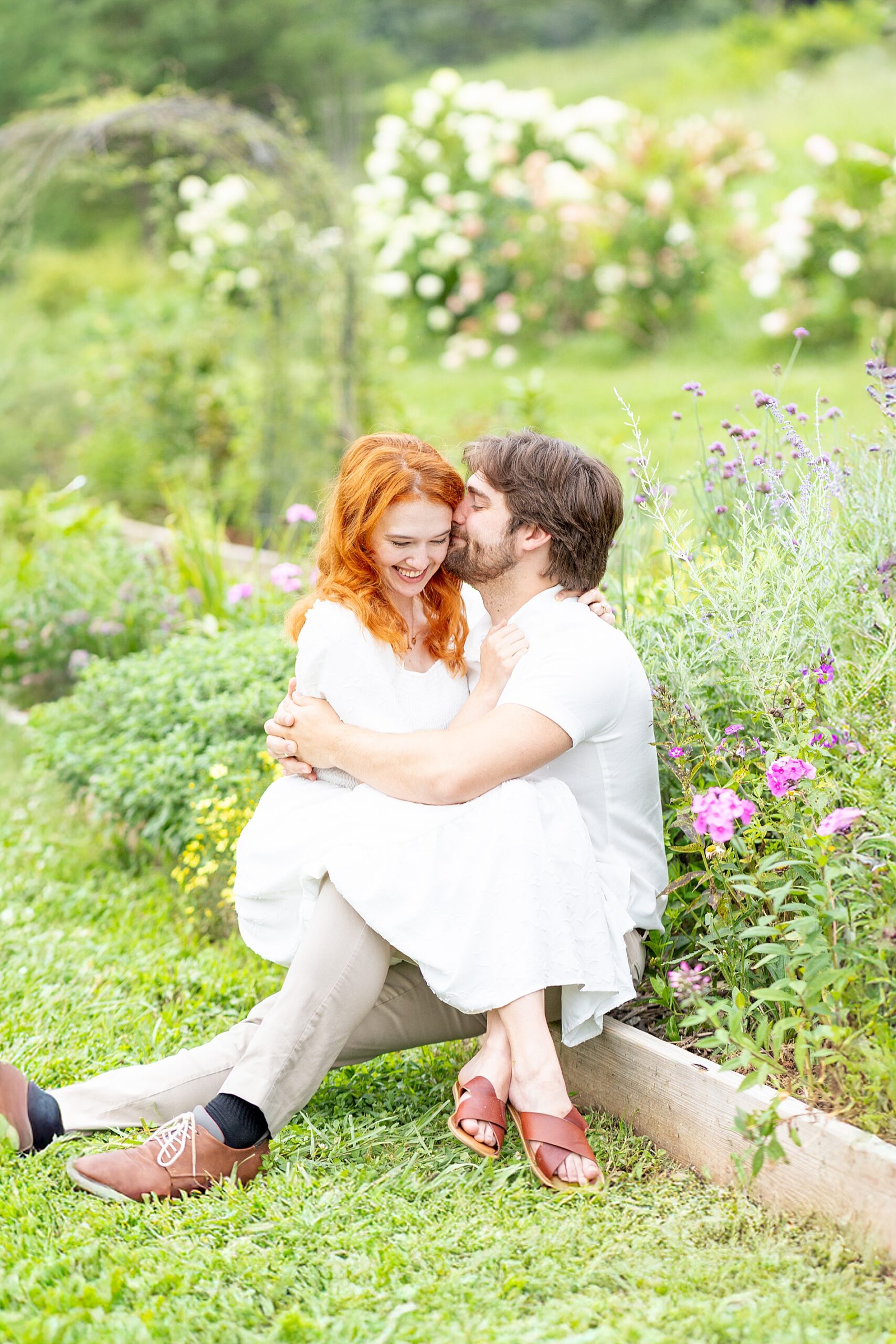 couple sitting together in field of flowers