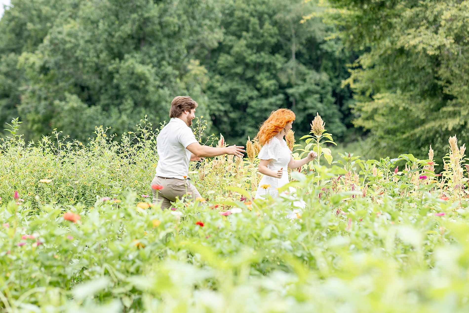 couple runs through field together 