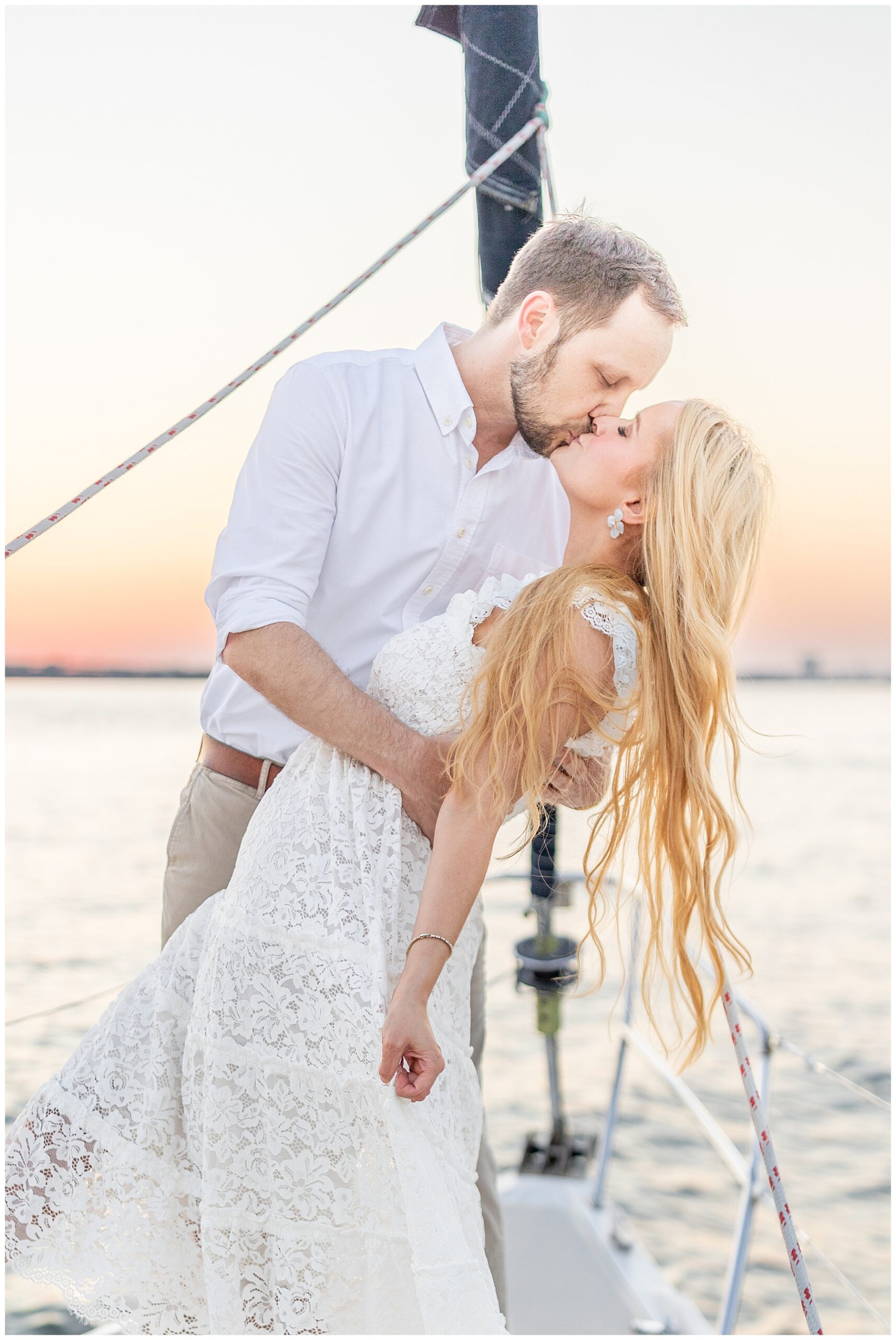 Newlyweds kiss during Charleston Harbor Wedding Portraits on a Sailboat by Charleston wedding photographer 