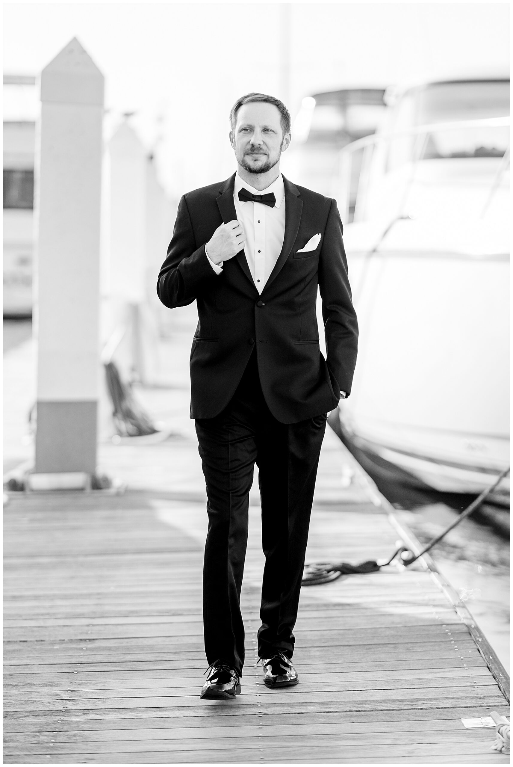 timeless groom portraits on dock by sailboat 