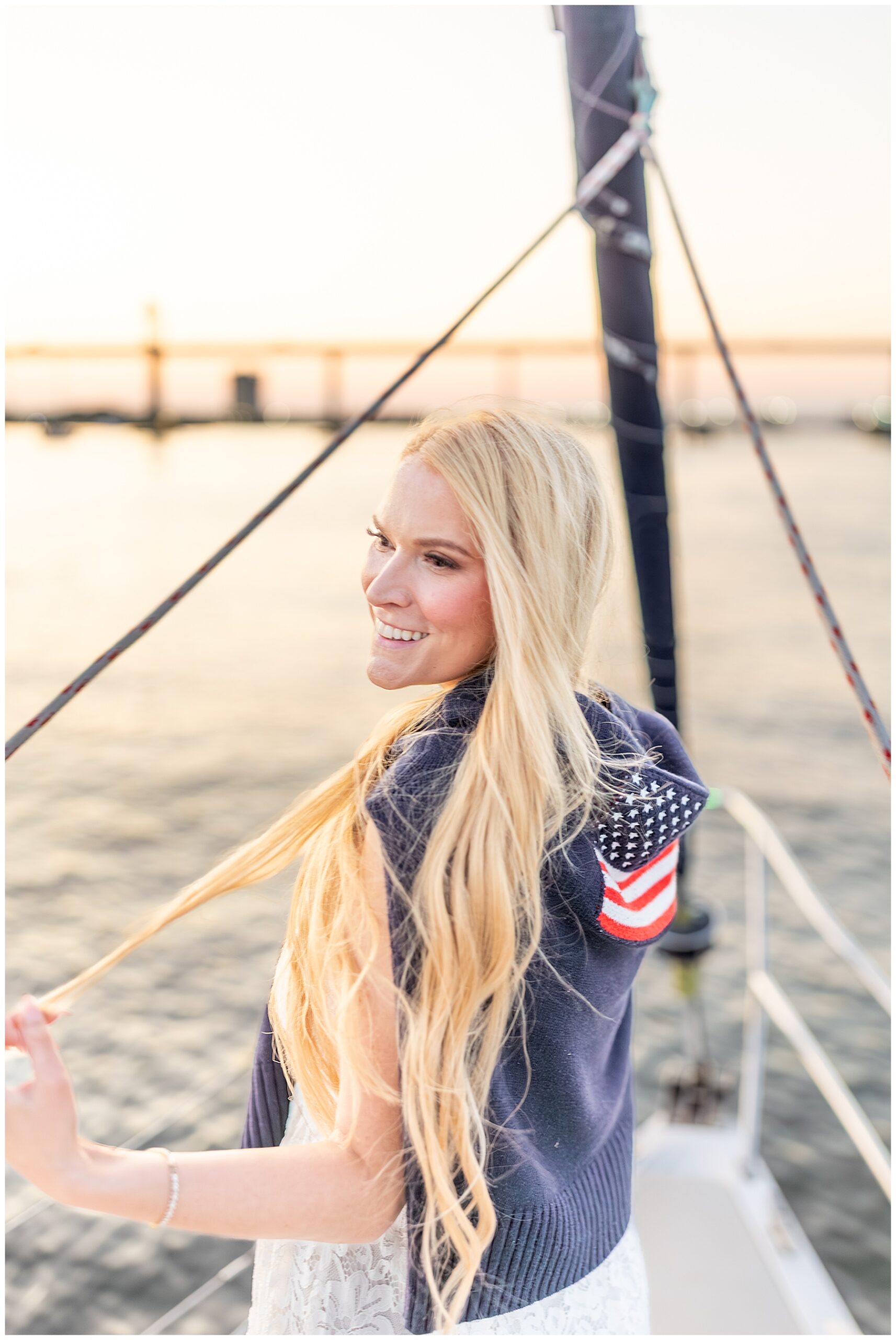 bride smiles as she watches the sunset and water from sailboat in charleston Harbor