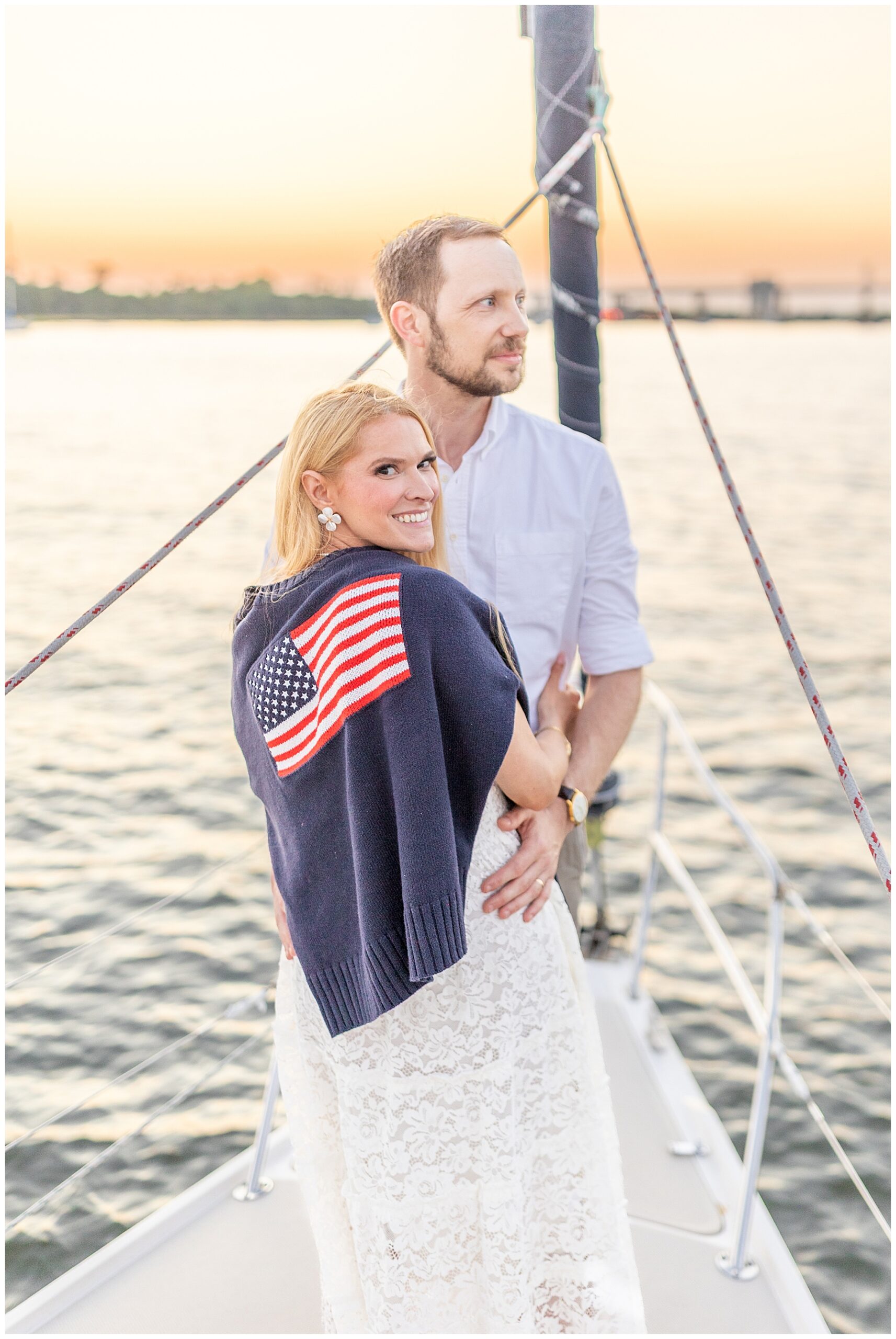 newlyweds watch the sunset from a sailboat during wedding portraits 