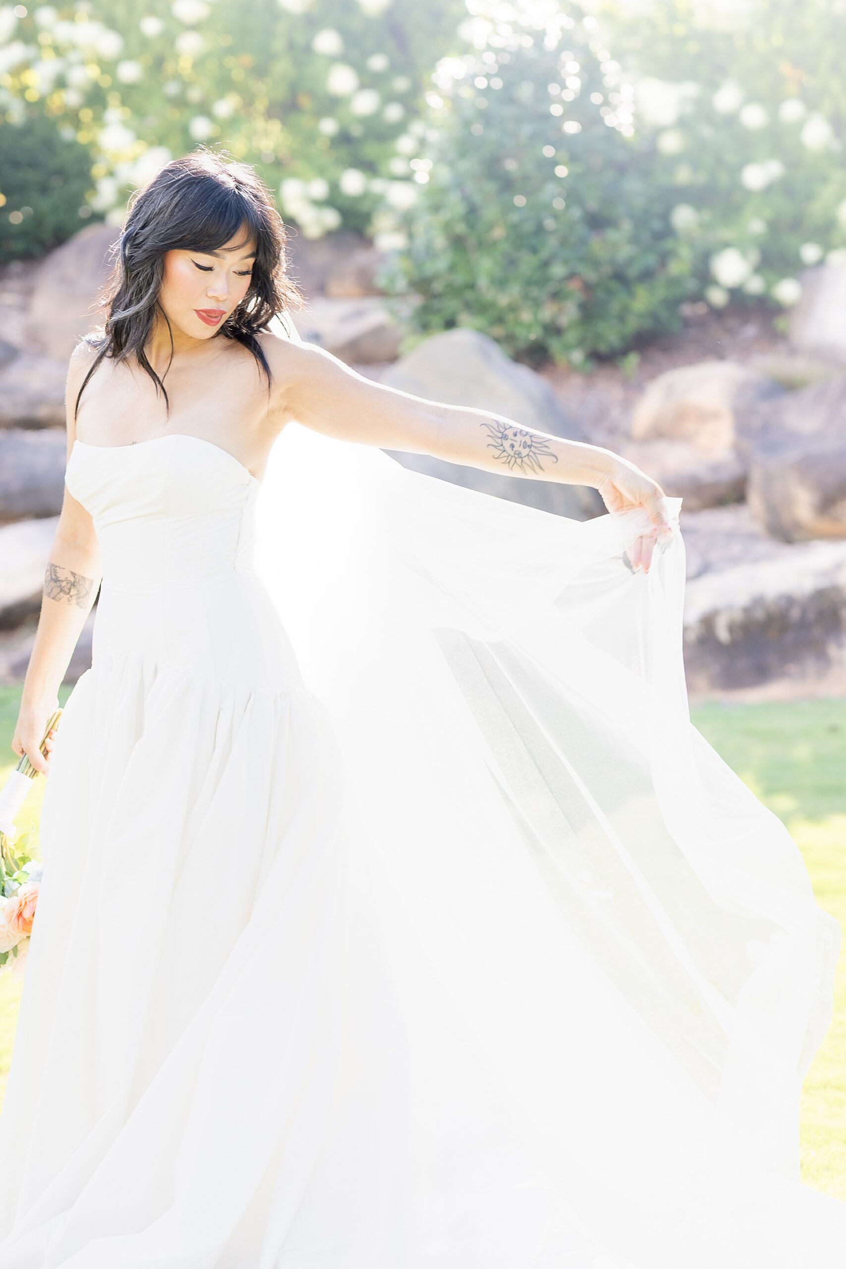 bride holds out train of dress 