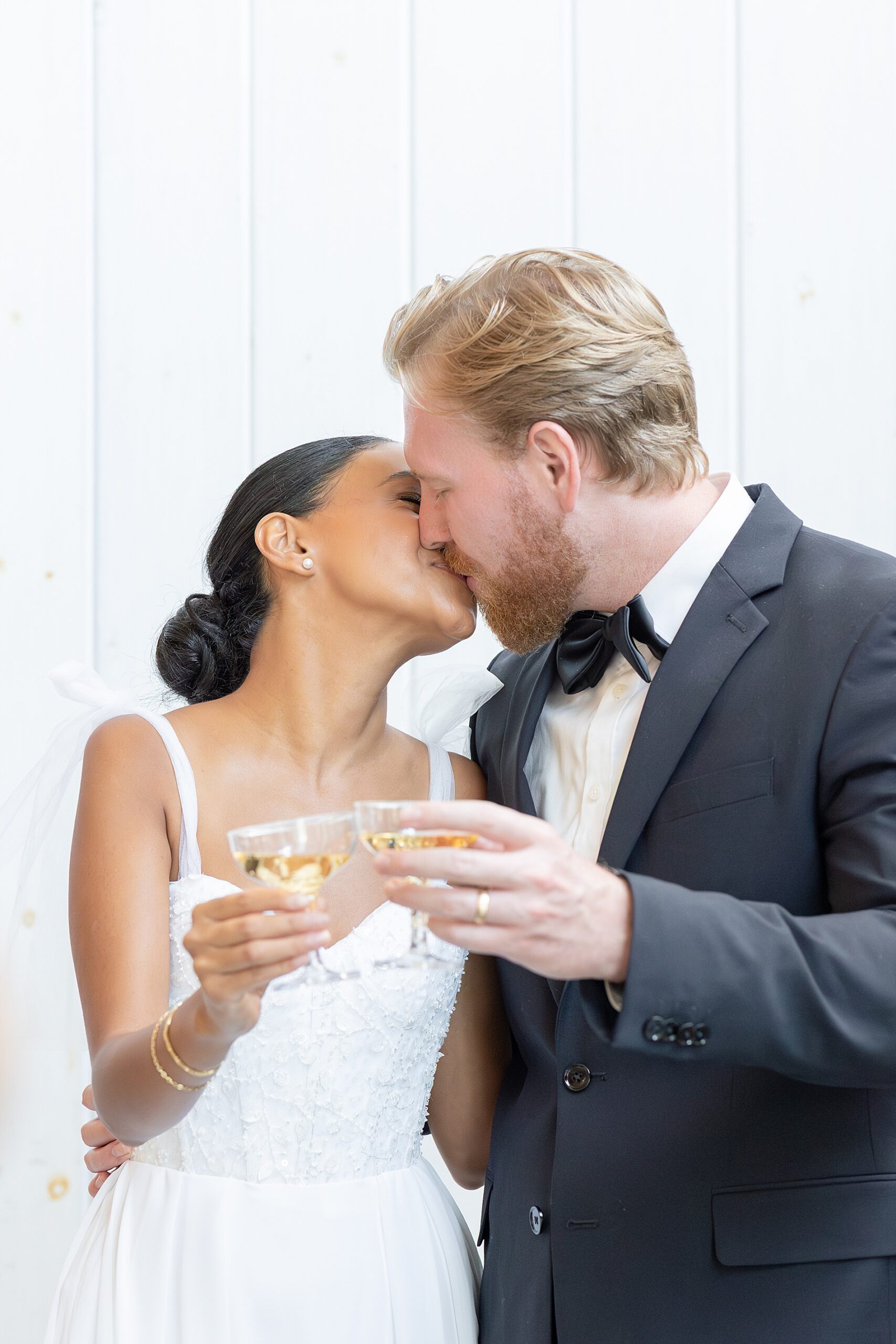 couple kiss as they toast with champagne 