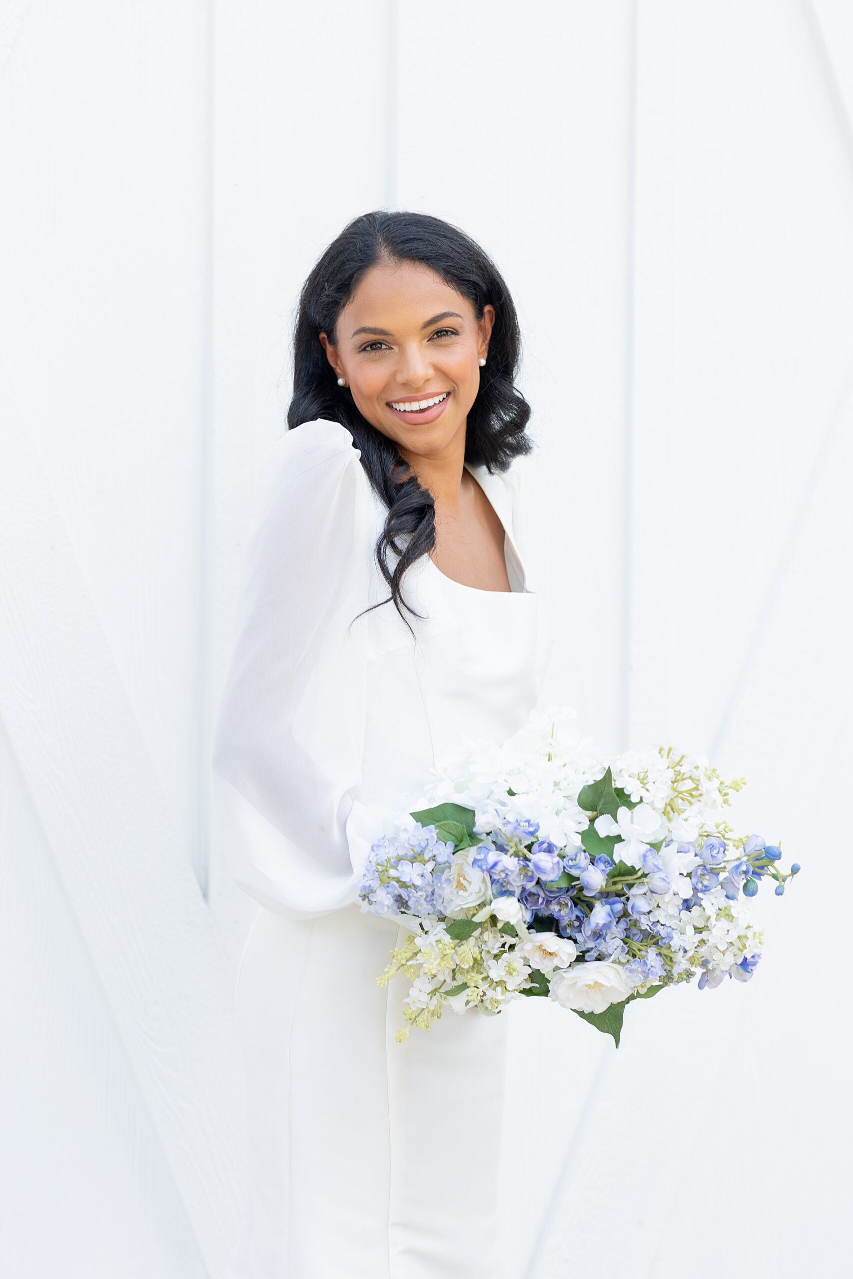 elegant bride holding white and blue wedding bouquet