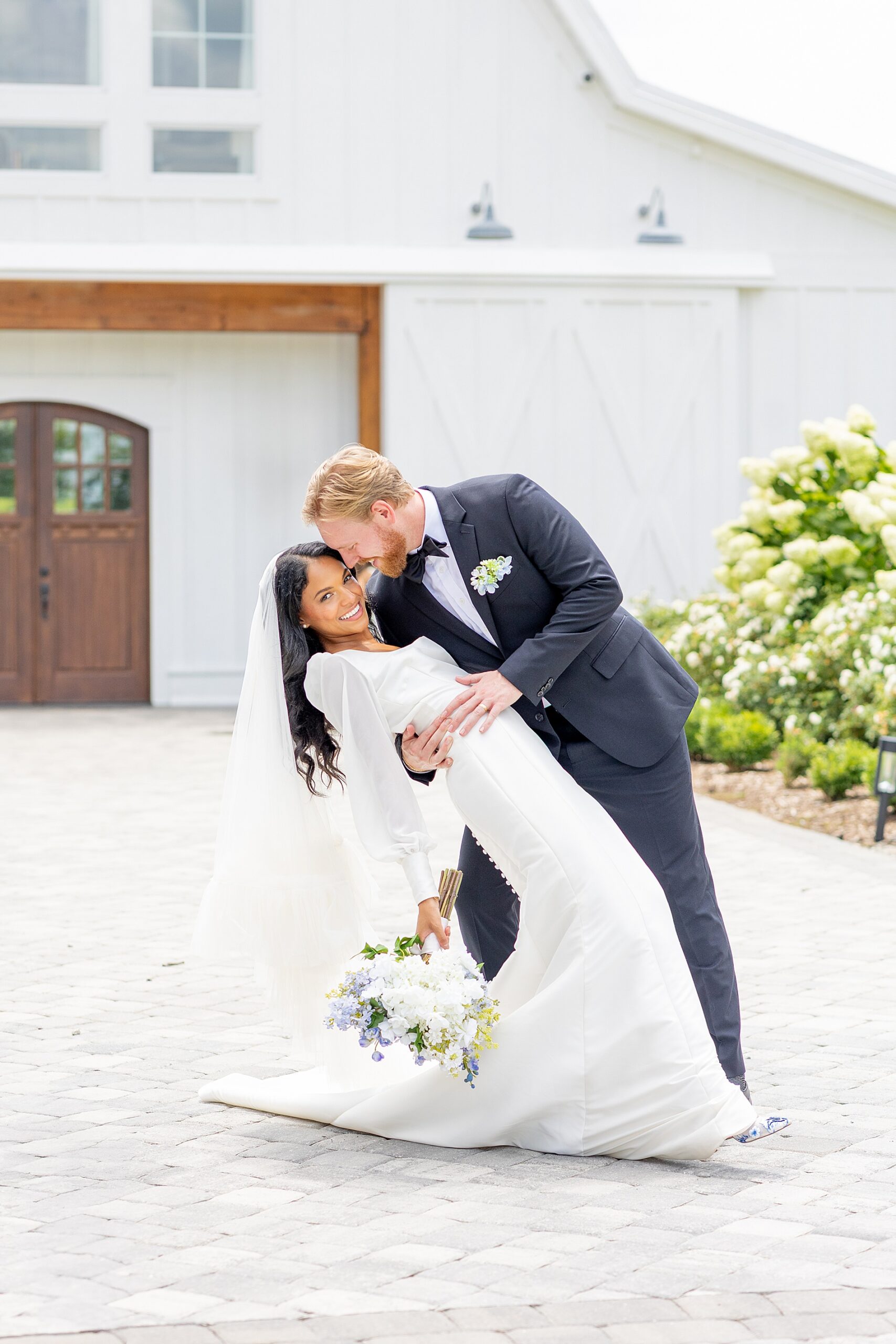 groom dips bride outside of Heyward Manor