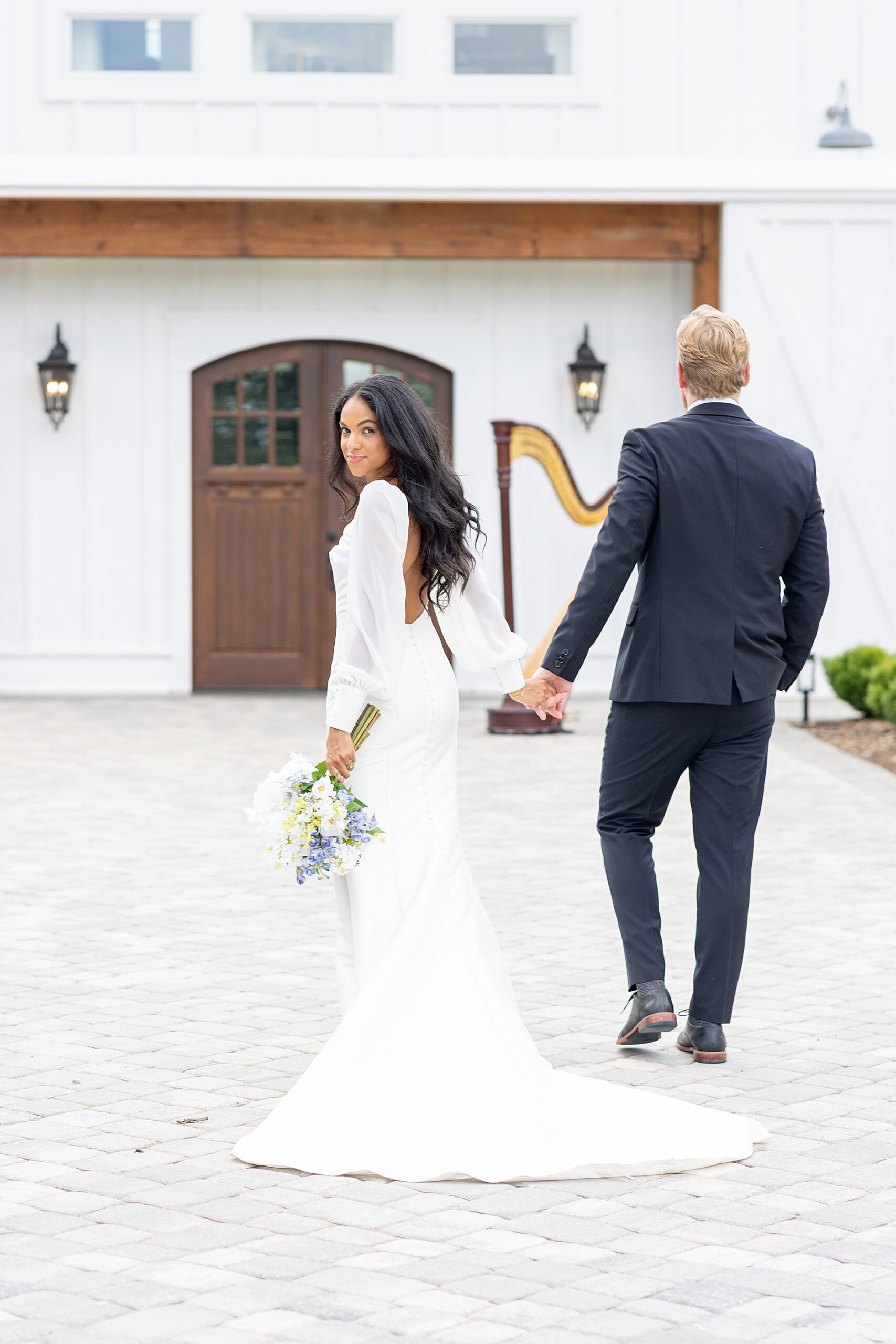 bride and groom hold hands as they walk together